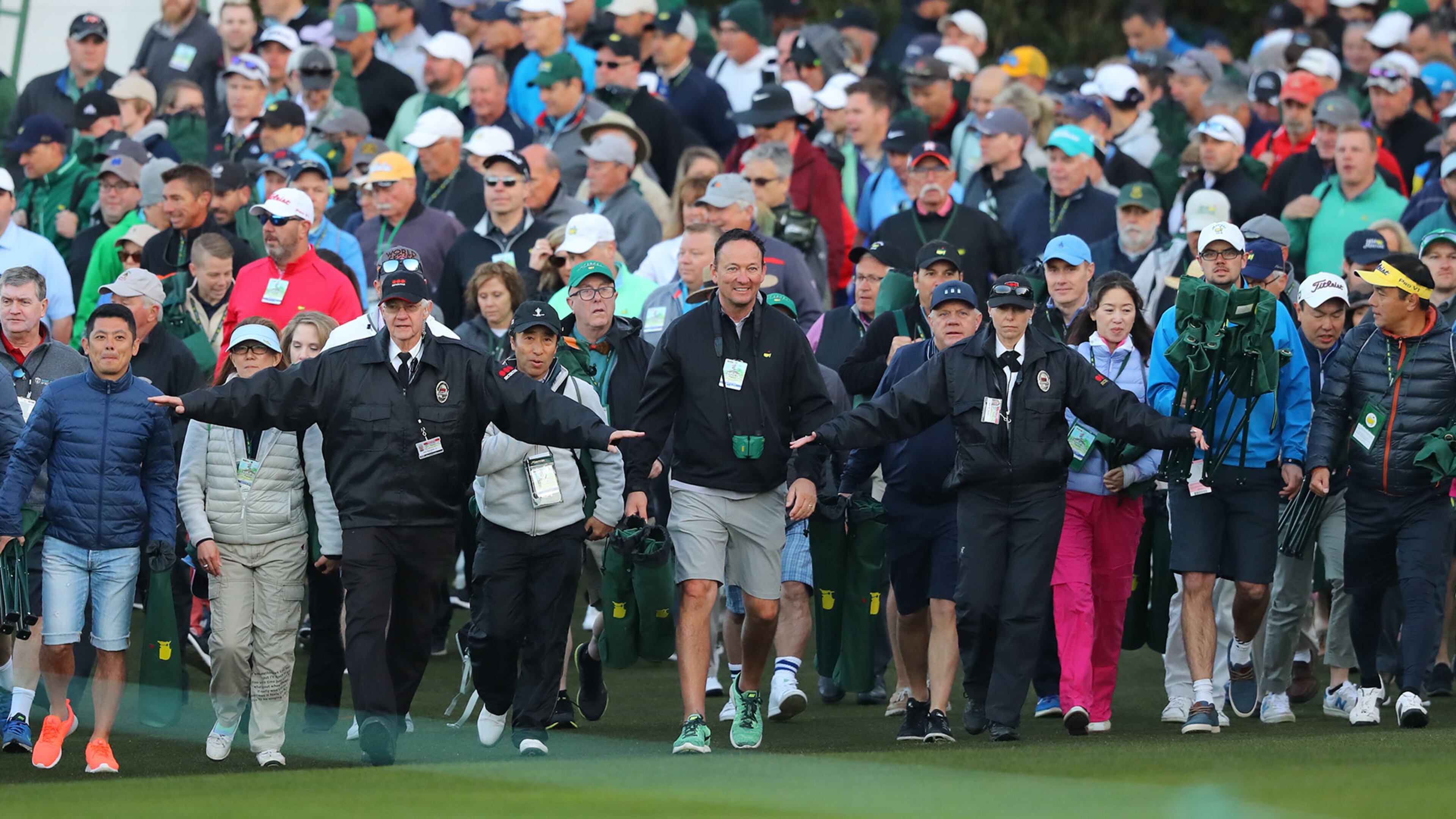Security guards walk the patrons in as the gates open during the begin the first round of the Masters Tournament Thursday, April 5, 2018, at Augusta National Golf Club.
