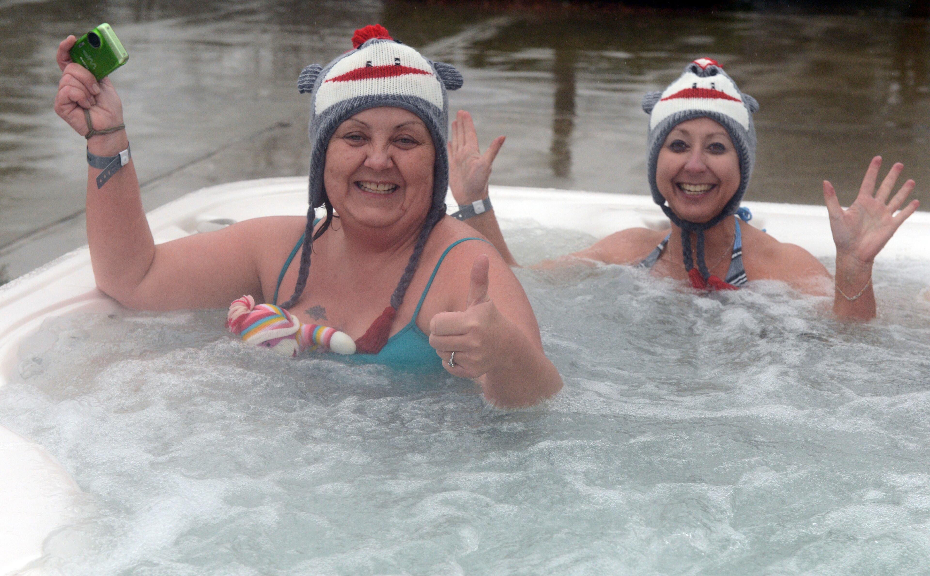JANUARY 1, 2013 GAINESVILLE Kathy Pierce of Buford (LEFT) and Karen Roberts of Flowery Branch warm up in the hot tub following their swim. Participants braved 48 degree water for the 16th annual Polar Bear Swim at the Lanier Canoe & Kayak Club Tuesday Jan. 1, 2013. The 16th annual Polar Bear Swim is a New Years tradition for the club. About 100 people took a polar plunge, despite rain and temperatures in the upper 40's. The event is a fundraiser for LCKC, with proceeds going to benefit the club's youth programs and other activities. Participants warmed up in a hot tub, got an event T-shirt, a bowl of chili and a drink to warm their bones. KENT D. JOHNSON / KDJOHNSON@AJC.COM