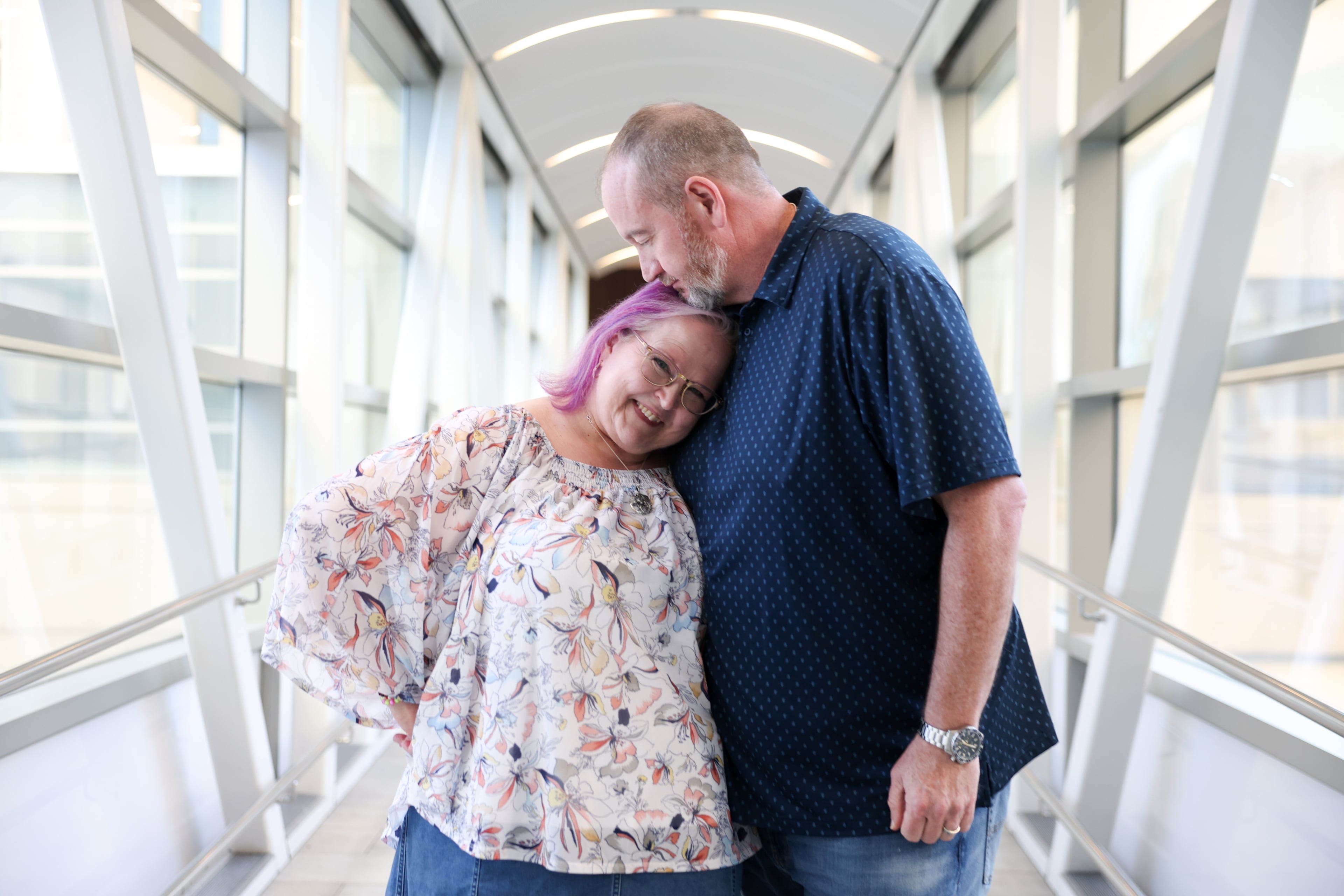 Tyra and Shane Burton pose on the sky bridge from the Hyatt Regency in Atlanta on Aug. 19, 2026. The couple met at Dragon Con at the Hyatt Regency in 2009. (Arvin Temkar/AJC)