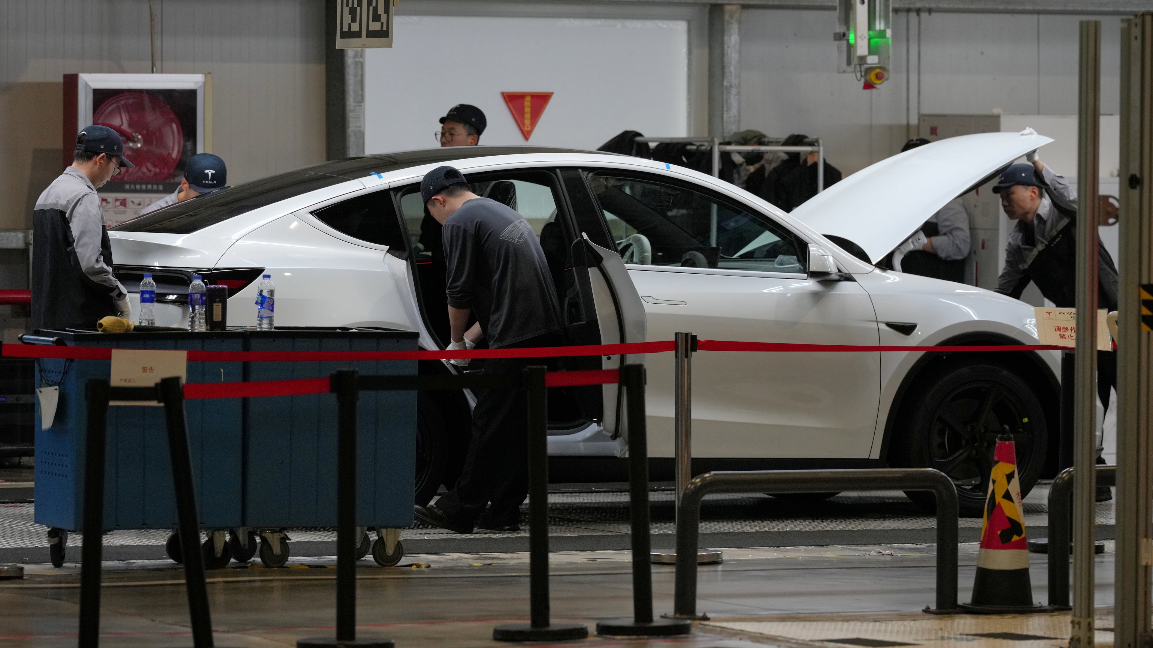 FILE - People work on the Tesla Model Y production line at the Tesla Gigafactory assembly plant during a media organized tour, in Shanghai, China, Tuesday, April 14, 2026. (AP Photo/Andy Wong, File)