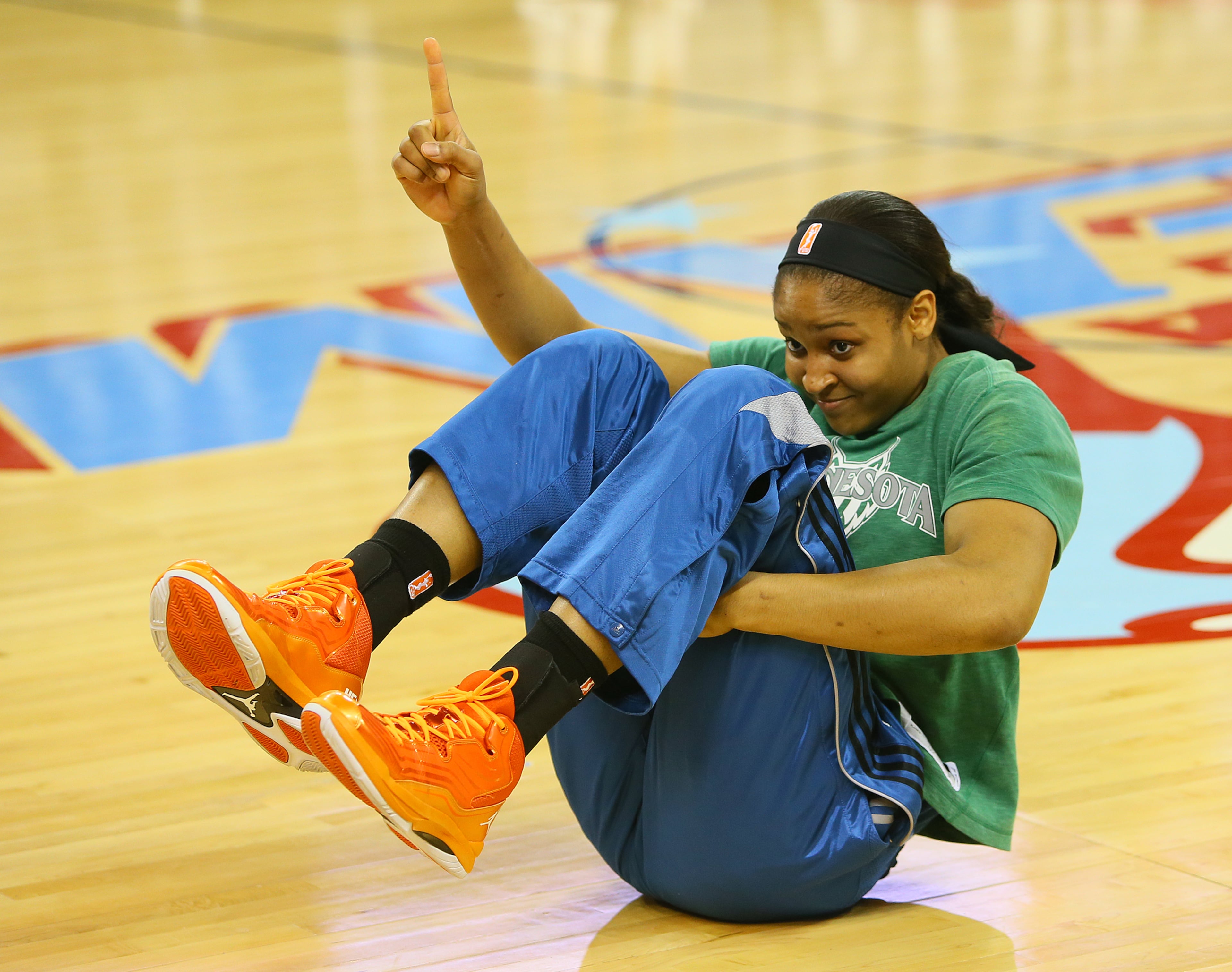 Minnesota forward Maya Moore flashes number one at fans while warming up for the WNBA Finals basketball game 3 against the Atlanta Dream on Thursday, Oct. 10, 2013, in Duluth.