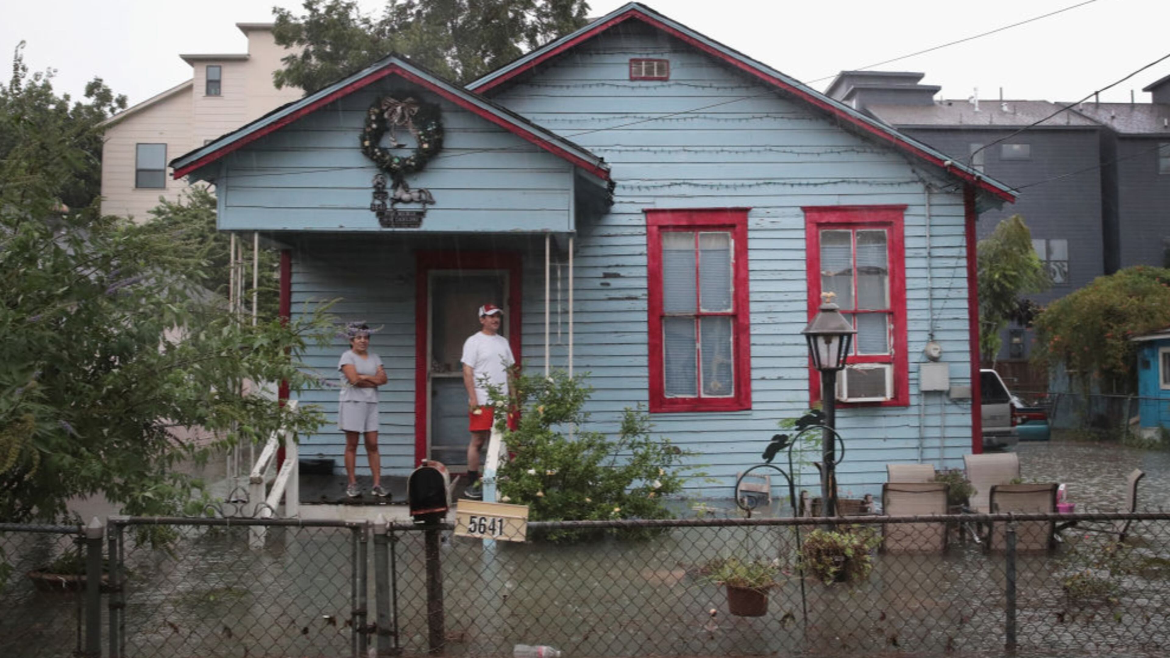 HOUSTON, TX - AUGUST 27: People on a porch watch as rain from Hurricane Harvey inundates the Cottage Grove neighborhood on August 27, 2017 in Houston, Texas. Harvey, which made landfall north of Corpus Christi late Friday evening, is expected to dump upwards to 40 inches of rain in Texas over the next couple of days. (Photo by Scott Olson/Getty Images)