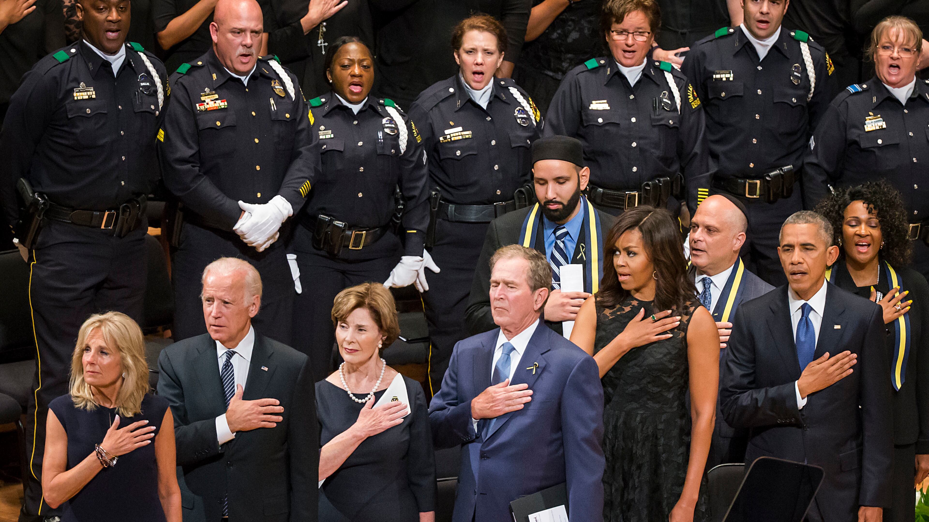 From left, Jill Biden, Vice President Joe Biden, former first lady Laura Bush, former President George W. Bush, Michelle Obama and President Barak Obama stand for the national anthem during an interfaith memorial service at the Morton H. Meyerson Symphony Center in Dallas on Tuesday, July 12, 2016, for five law enforcement officers killed last week in an ambush at a Black Lives Matter rally. (Smiley N. Pool/The Dallas Morning News via AP) /The Dallas Morning News via AP) MANDATORY CREDIT; MAGS OUT; TV OUT; INTERNET USE BY AP MEMBERS ONLY; NO SALES