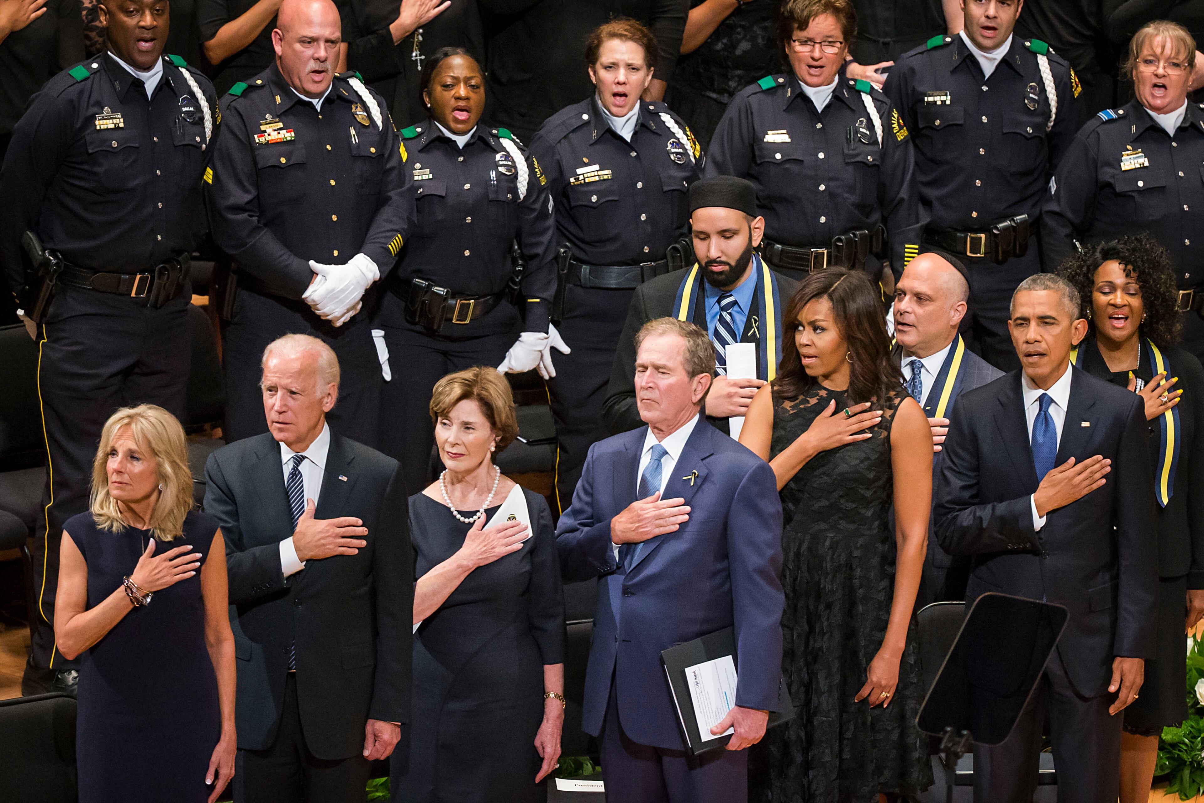 From left, Jill Biden, Vice President Joe Biden, former first lady Laura Bush, former President George W. Bush, Michelle Obama and President Barak Obama stand for the national anthem during an interfaith memorial service at the Morton H. Meyerson Symphony Center in Dallas on Tuesday, July 12, 2016, for five law enforcement officers killed last week in an ambush at a Black Lives Matter rally. (Smiley N. Pool/The Dallas Morning News via AP) /The Dallas Morning News via AP) MANDATORY CREDIT; MAGS OUT; TV OUT; INTERNET USE BY AP MEMBERS ONLY; NO SALES