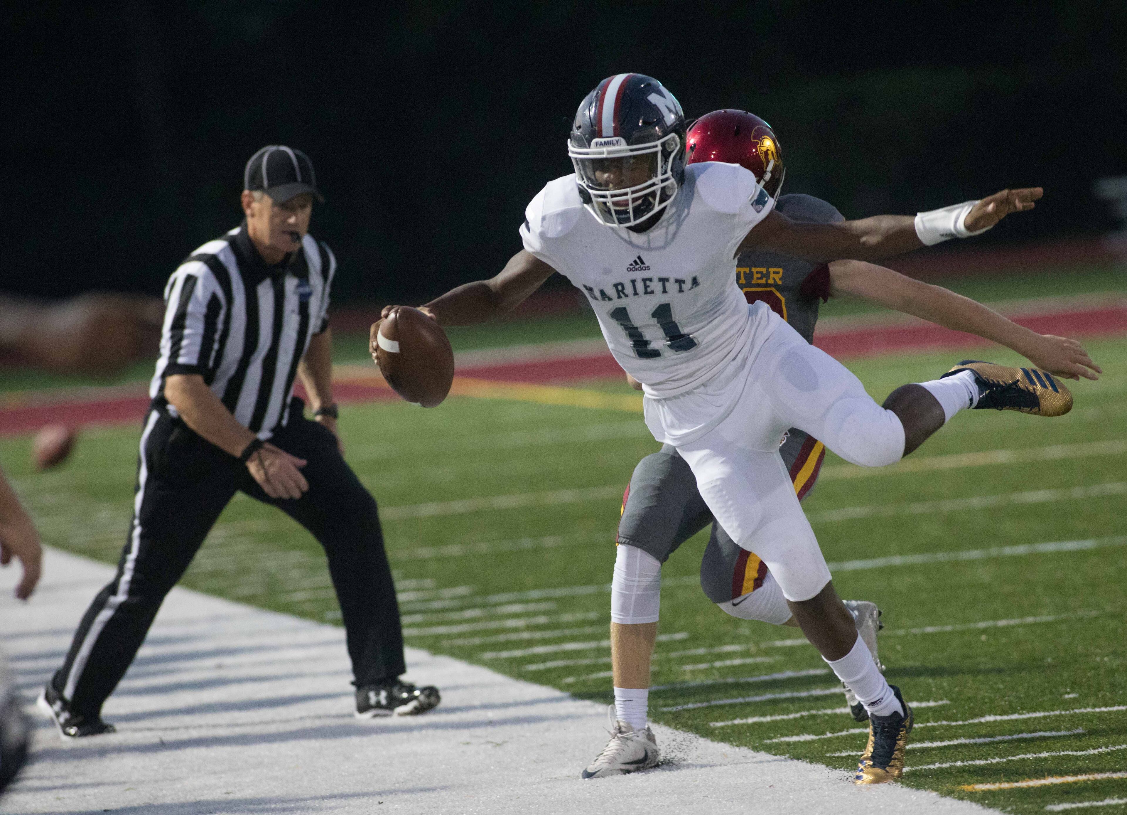 Marietta High School quarterback Rashun Bass (11) is pushed out of bounds by Lassiter High School's Colin Wegman during the first half of a high school football game, Friday, Sept. 15, 2017, in Marietta, Ga. BRANDEN CAMP/SPECIAL