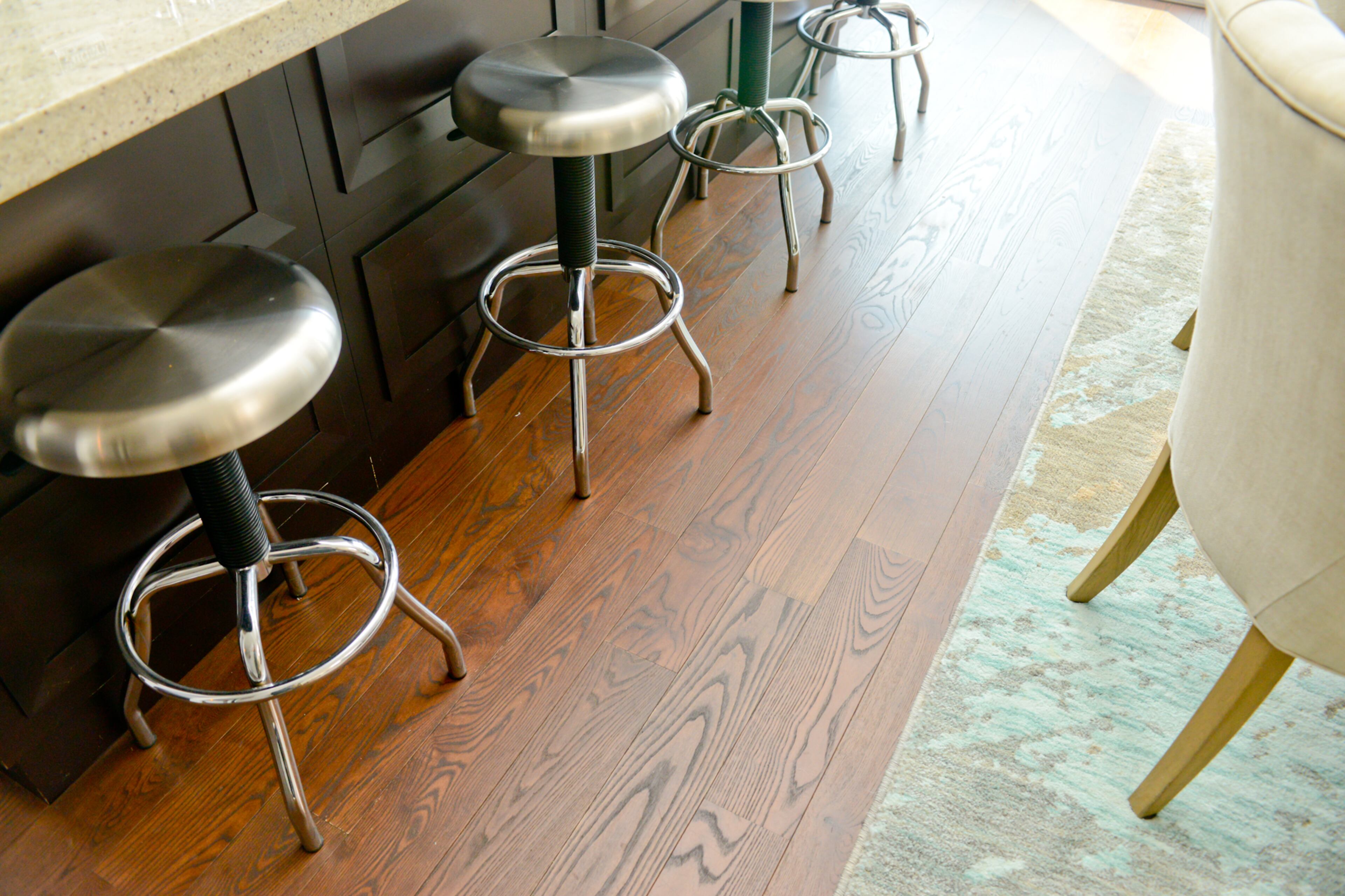 Tucked underneath a counter-height bar, four brushed-metal barstools add an edgy, slightly industrial feel to the transitional decor. The real estate broker snatched the barstools up when he spotted them on barstools.com.