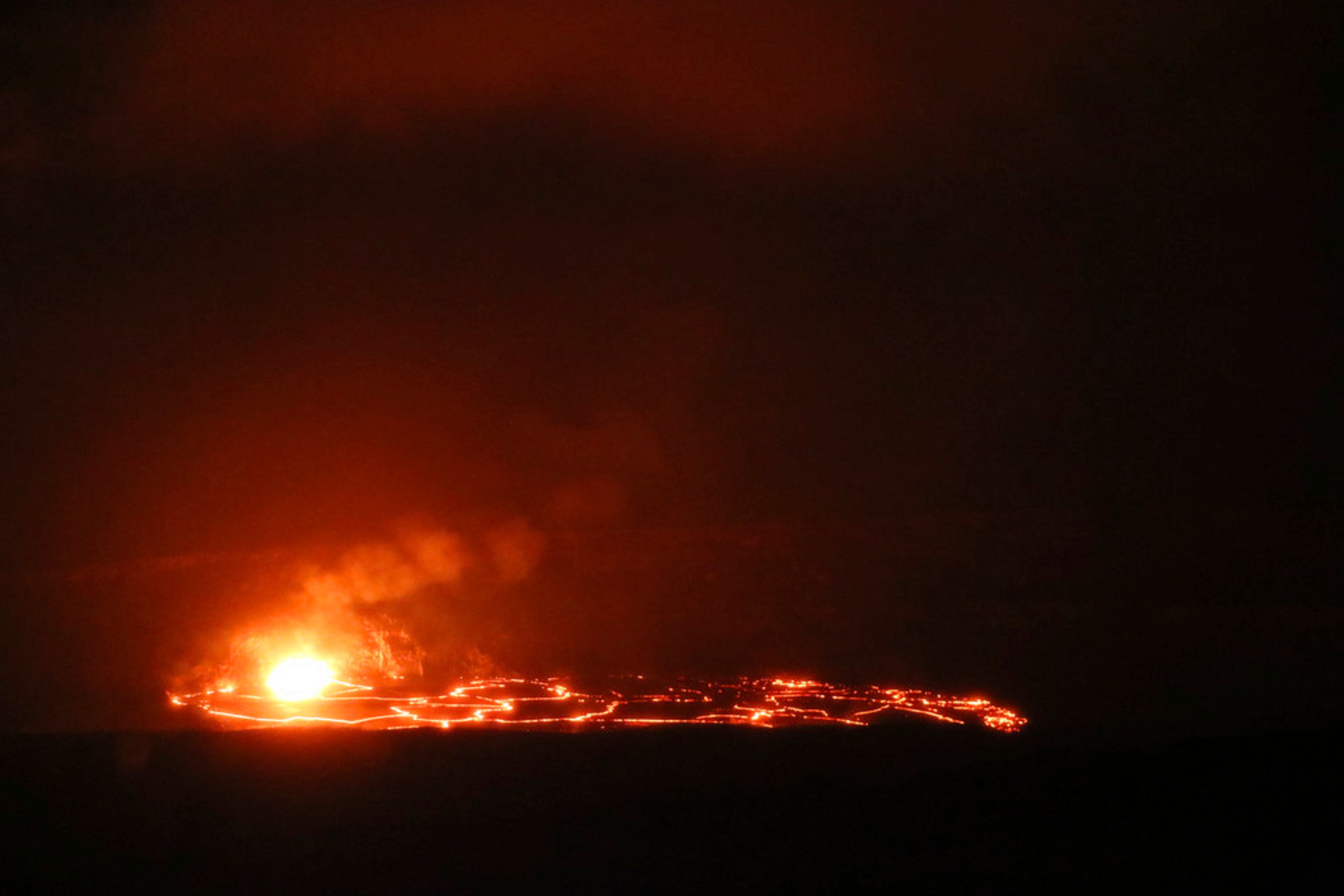 In this April 24, 2018 photo provided by the U.S. Geological Survey, Kilauea Volcano's summit lava lake overflows onto Halemaumau Crater in Hawaii Volcanoes National Park on Hawaii's Big Island. Lava from Kilauea's summit lava lake continues to overflow intermittently out of its Overlook crater onto the floor of Halemaumau Crater, after recording its largest overflow since the summit vent opened up 10 years ago. Hawaiian Volcano Observatory scientists noted overflows again Wednesday morning around 8:30 a.m., after two episodes of activity Tuesday. (M. Patrick/U.S. Geological Survey via AP)