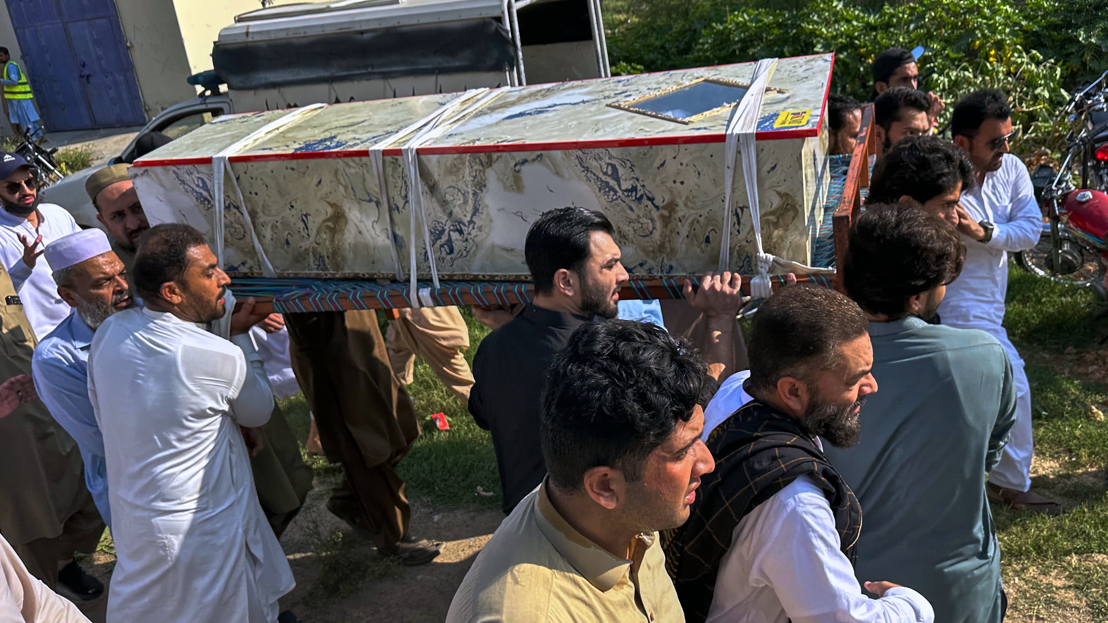 In this photo taken with a smartphone, mourners carry the casket of a victim who was killed in Friday's suicide bombing at a mosque, for a funeral in Kohat, in northwestern Pakistan, Saturday, Sept. 19, 2026. (AP Photo/Maaz Awan)