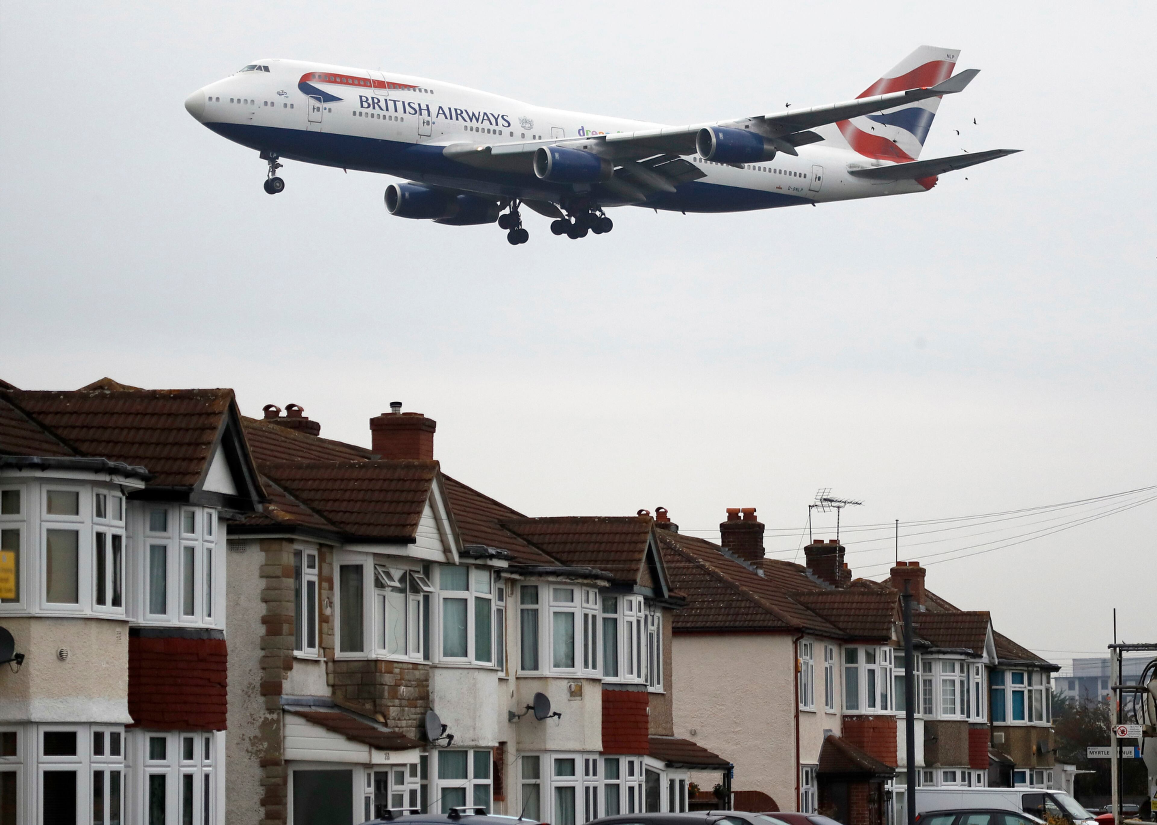 A plane approaches landing over the rooftops of nearby houses at Heathrow Airport in London, Tuesday, Oct. 25, 2016. Britain's government will reveal how it plans to expand London's airport capacity, more than a year after a special commission recommended a third runway at Heathrow. (AP Photo/Frank Augstein)