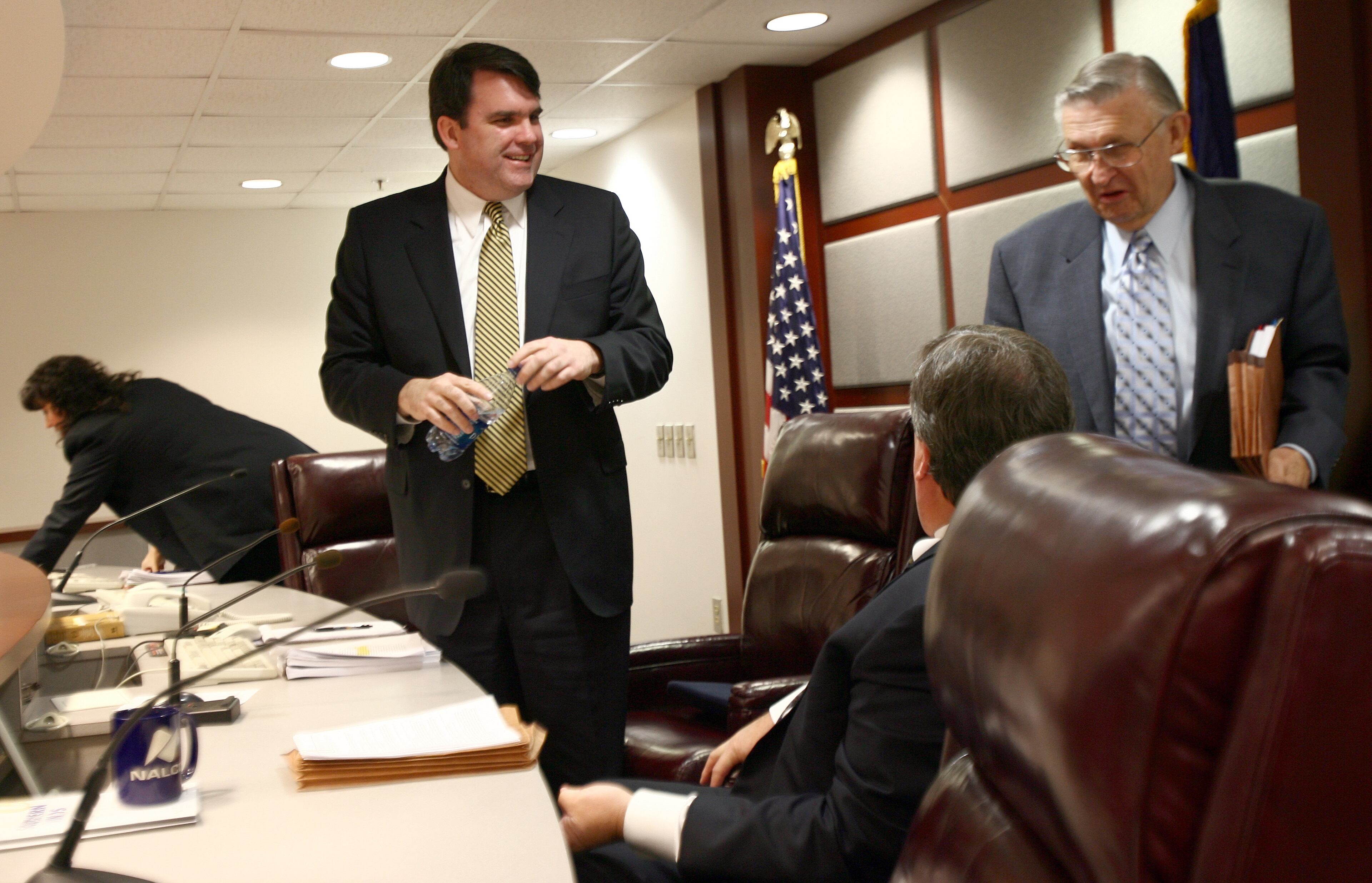 Chuck Eaton (cq), left, the new chairman of the Public Service Commission, talks with now-former commissioners Stan Wise (cq), center, and Doug Everett (cq) after presiding over an administrative session. (BEN GRAY / Staff)