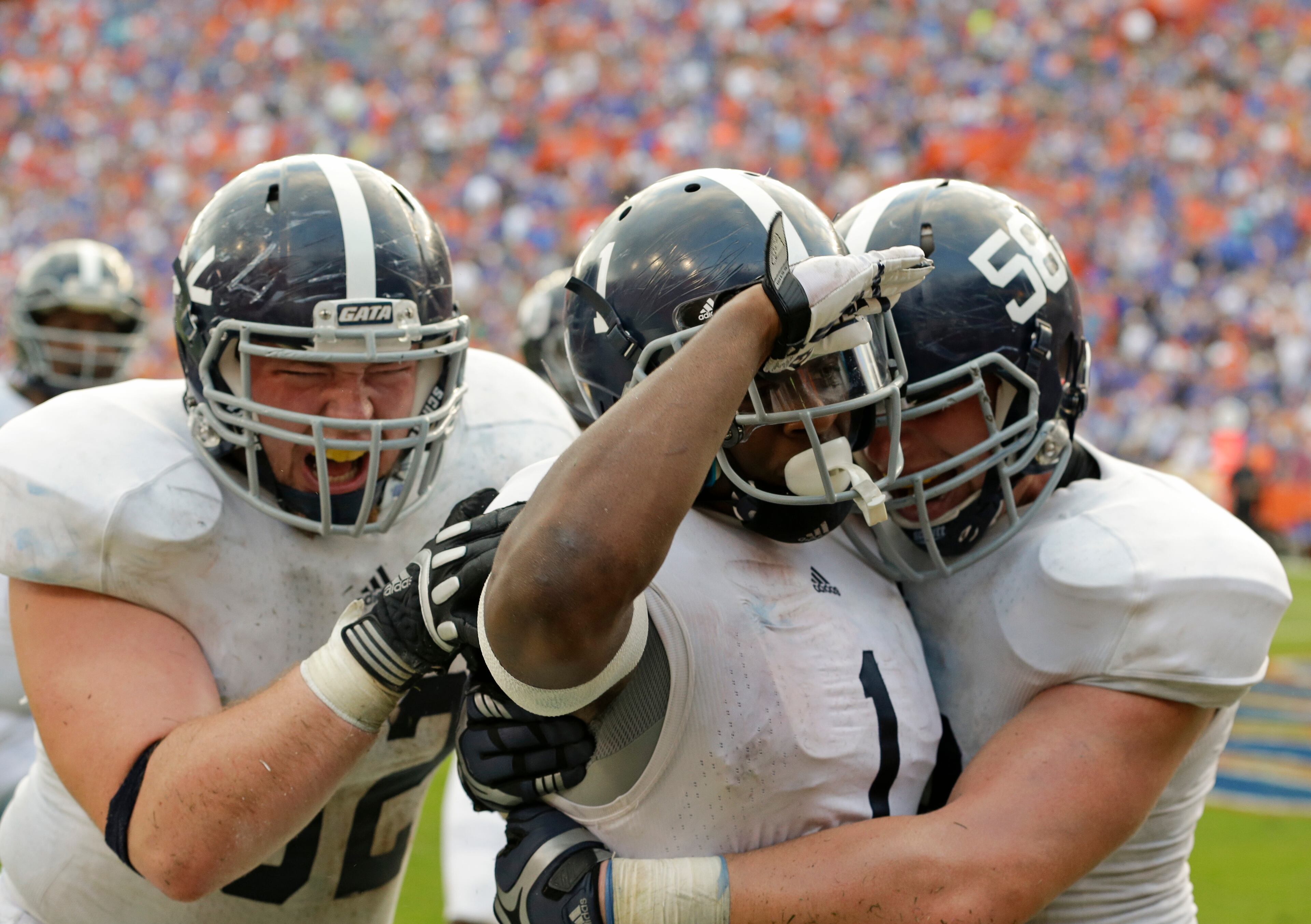 Georgia Southern's Jerick McKinnon (1) celebrates his winning touchdown on a 14-yard run against Florida with Zach Lonas, left, and Garrett Frye (58) during the second half of an NCAA college football game in Gainesville, Fla., Saturday, Nov. 23, 2013. Georgia Southern won the game 26-20.(AP Photo/John Raoux)