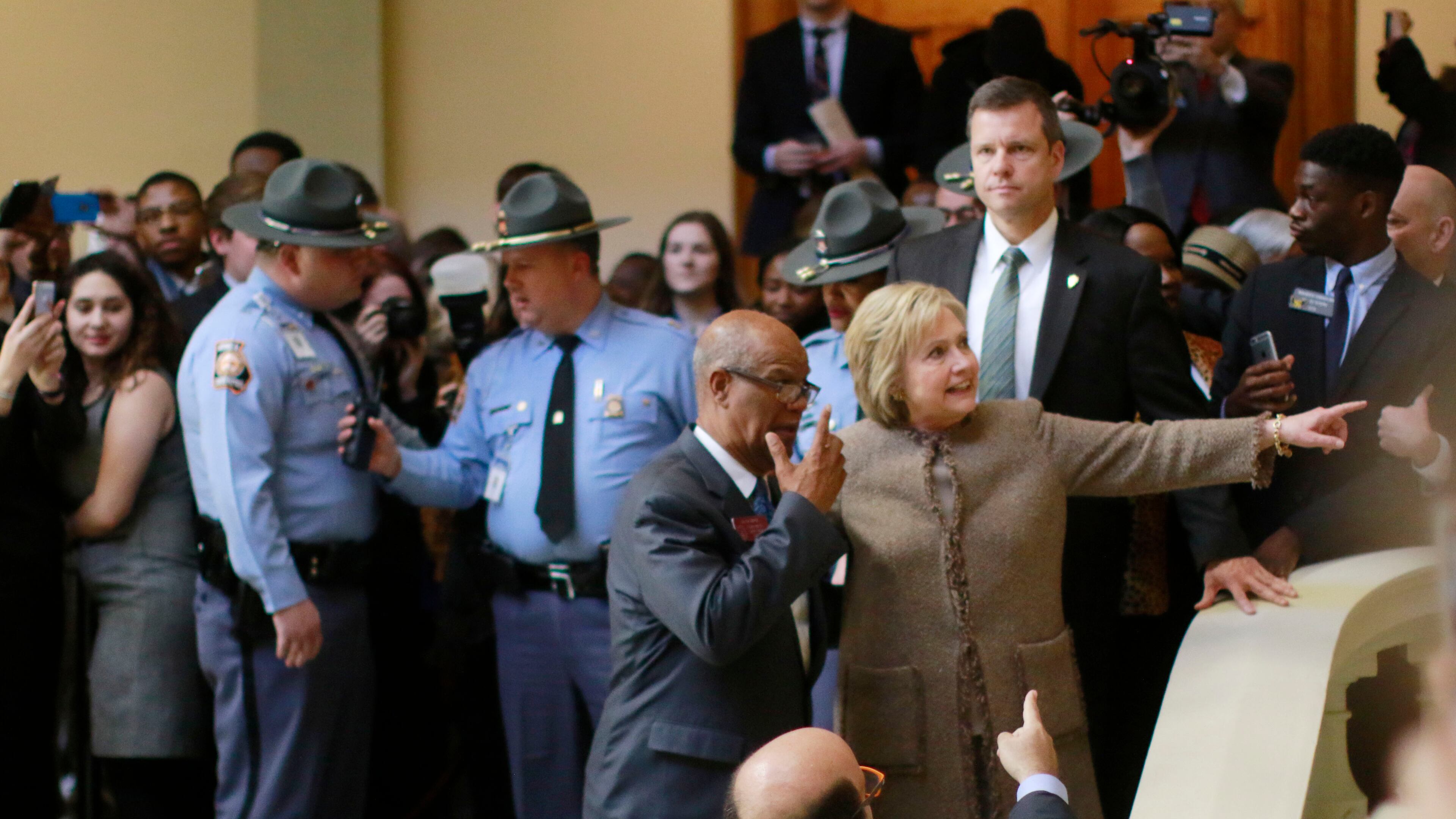 Hillary Clinton is escorted by state Rep. Calvin Smyre, D - Columbus, on Friday as she departed the Capitol. Bob Andres, bandres@ajc.com