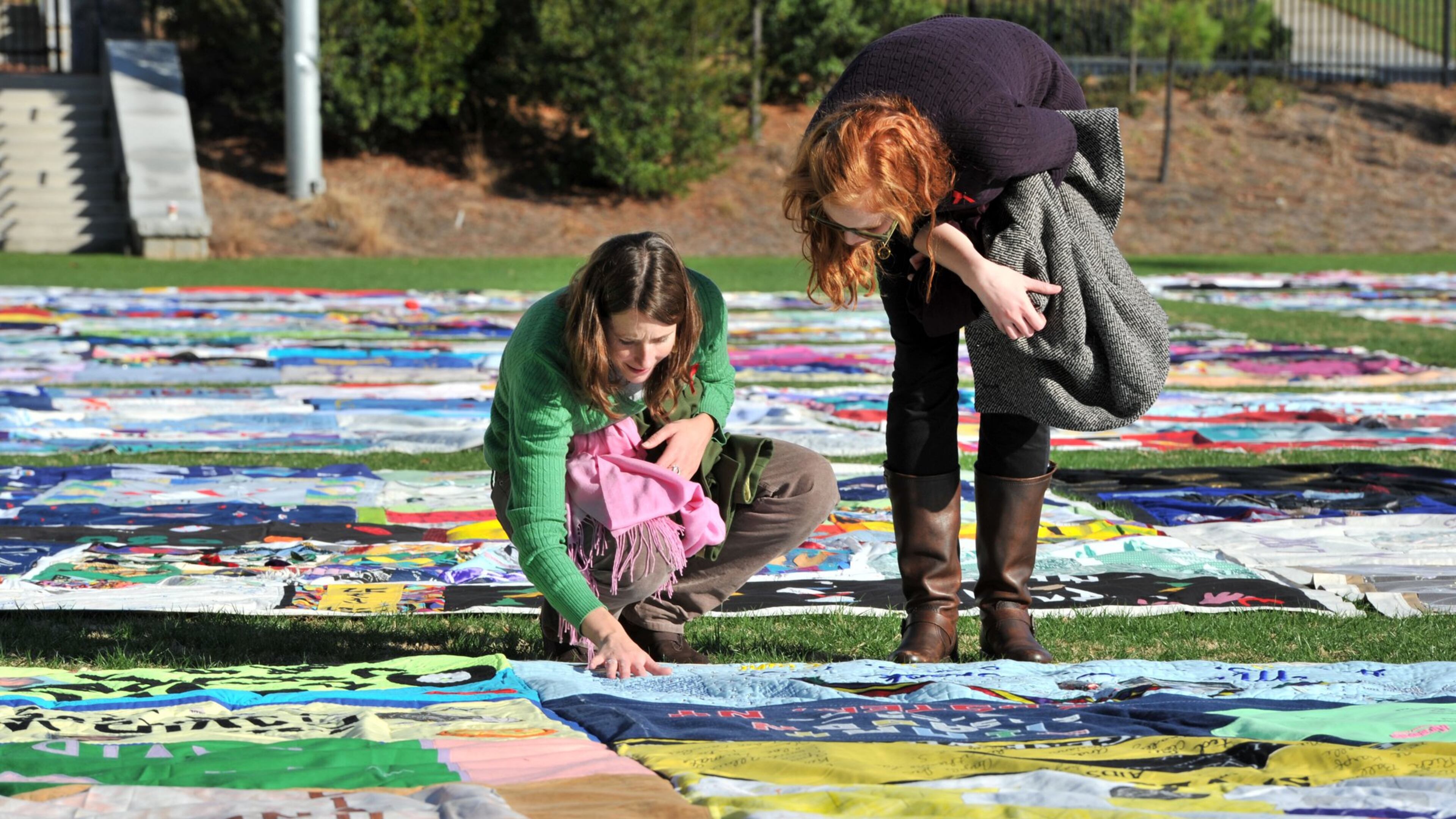 Kate Ogorzaly (left) and Meg Bertram stop for a closer look at the AIDS Memorial Quilt at Emory University’s McDonough Field. Members of an HIV/AIDS task force asked Fulton County for money and policy help to stop the spread of the disease. AJC FILE PHOTO