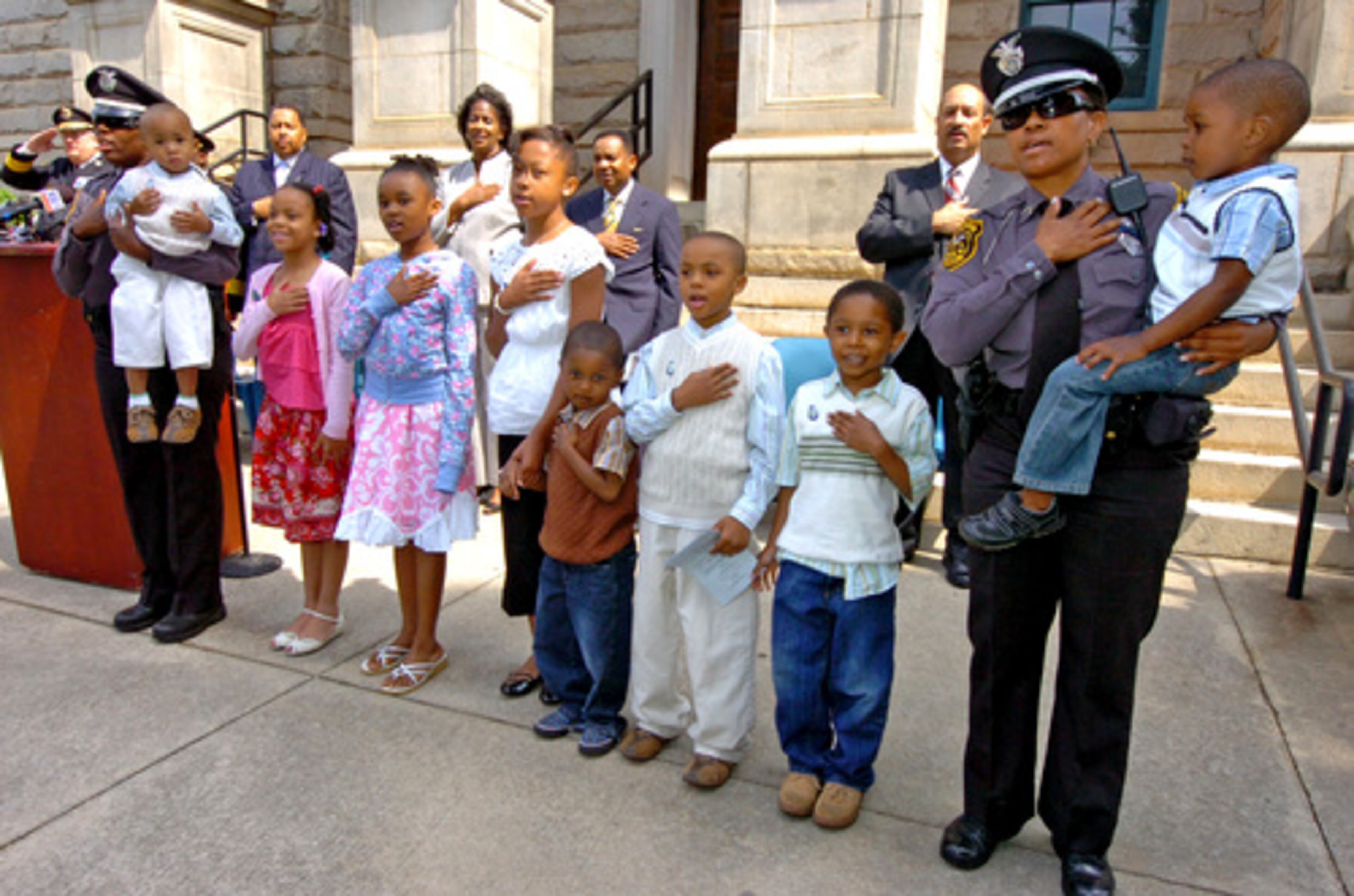The children of slain police officers Ricky Bryant Jr., and Eric Barker lead the Pledge of Allegiance.