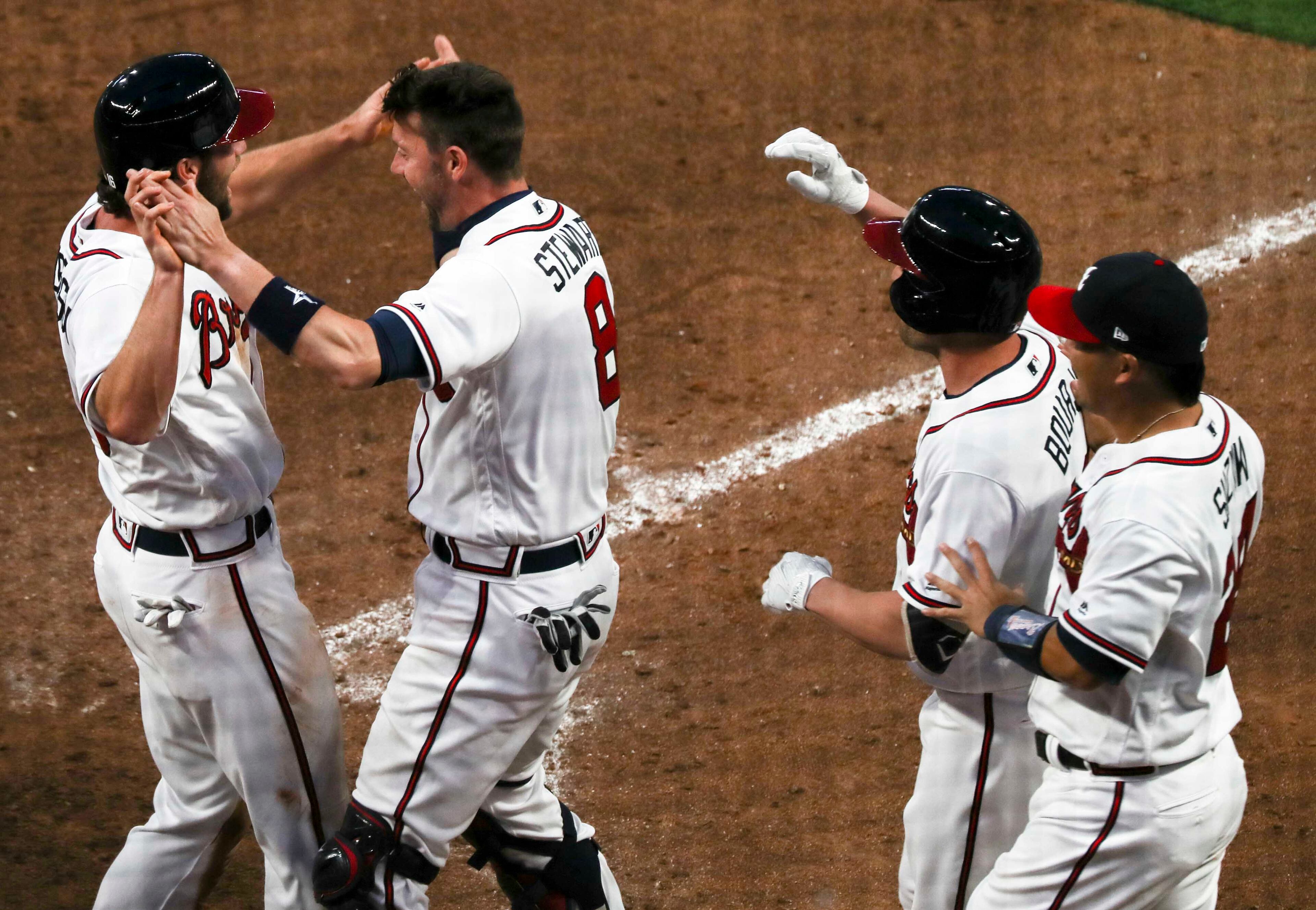 03/29/2018 -- Atlanta, GA - Charlie Culberson (16), left, is congratulated by his team members after scoring against the Philadelphia Phillies for the season opener game at SunTrust Park, Thursday, March 29, 2018. The Braves beat the Phillies, 8-5. ALYSSA POINTER/ALYSSA.POINTER@AJC.COM