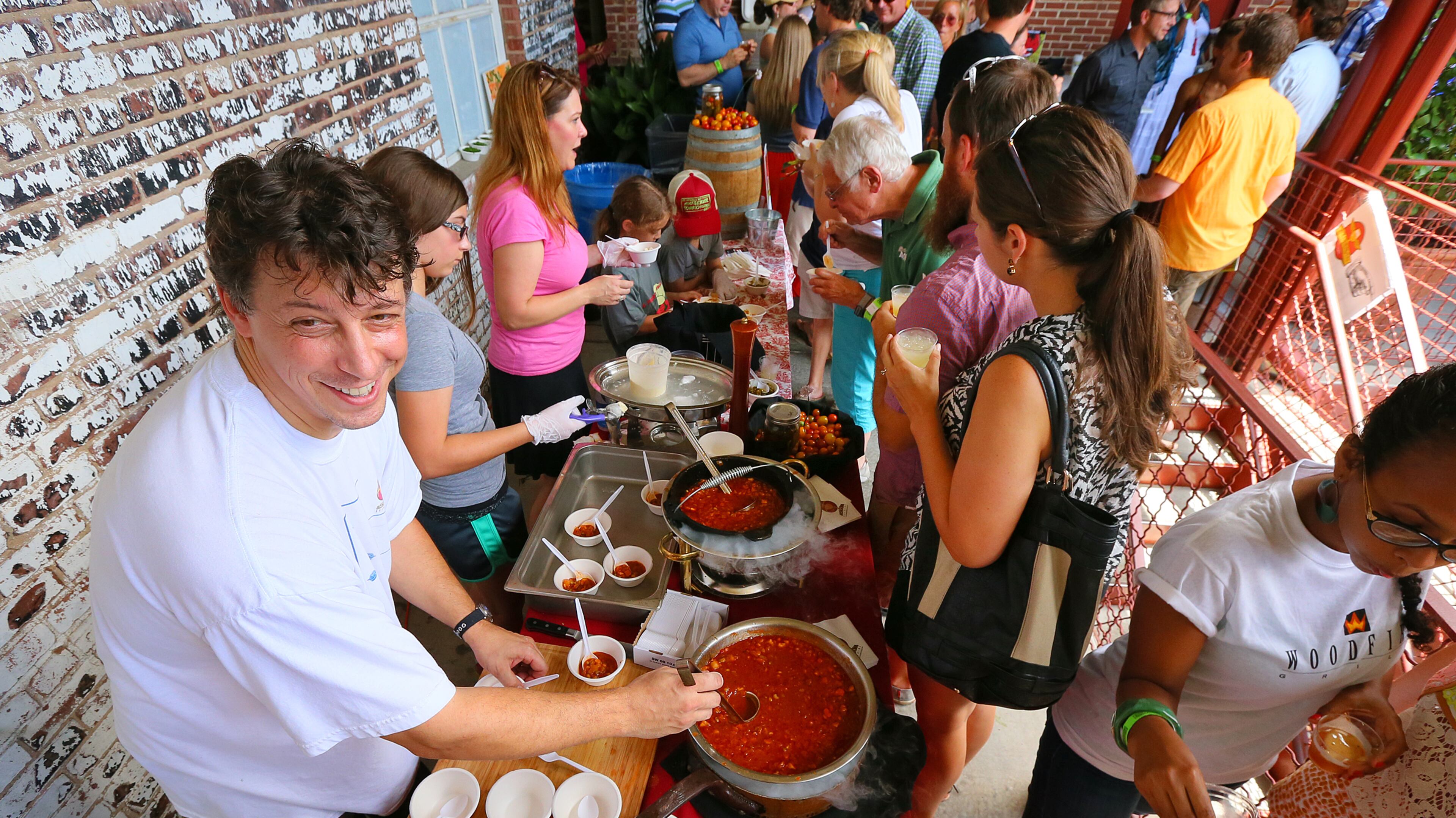Chef David Larkworthy, 5 Seasons Brewing, is all smiles dishing out his chili -- chili with beer cheddar ice cream at the Killer Tomato Festival.