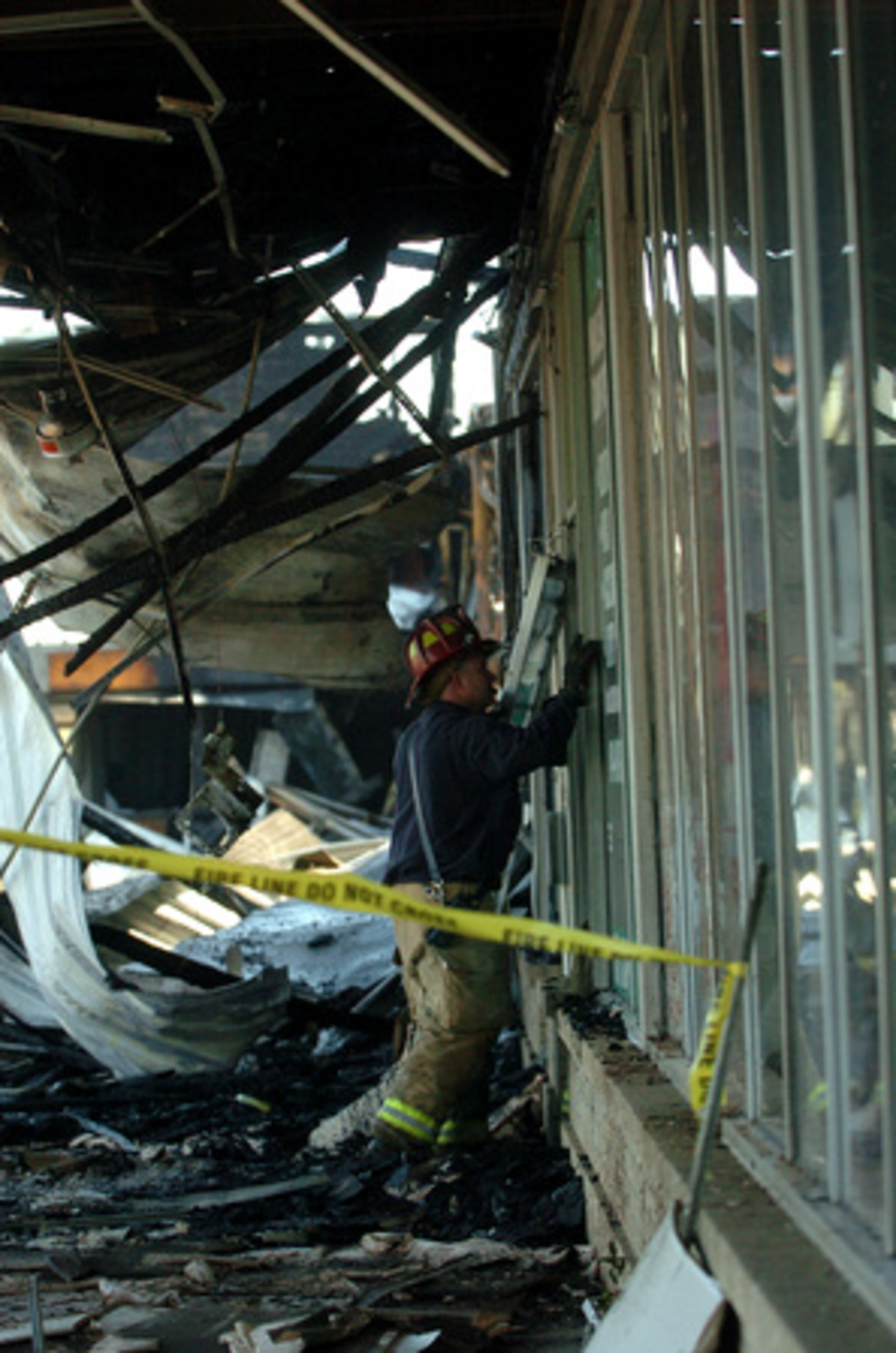Capt. Kevin Downing, of Dekalb County Fire Dept., looks into businesses after the explosion, the cause of which remains unknown.