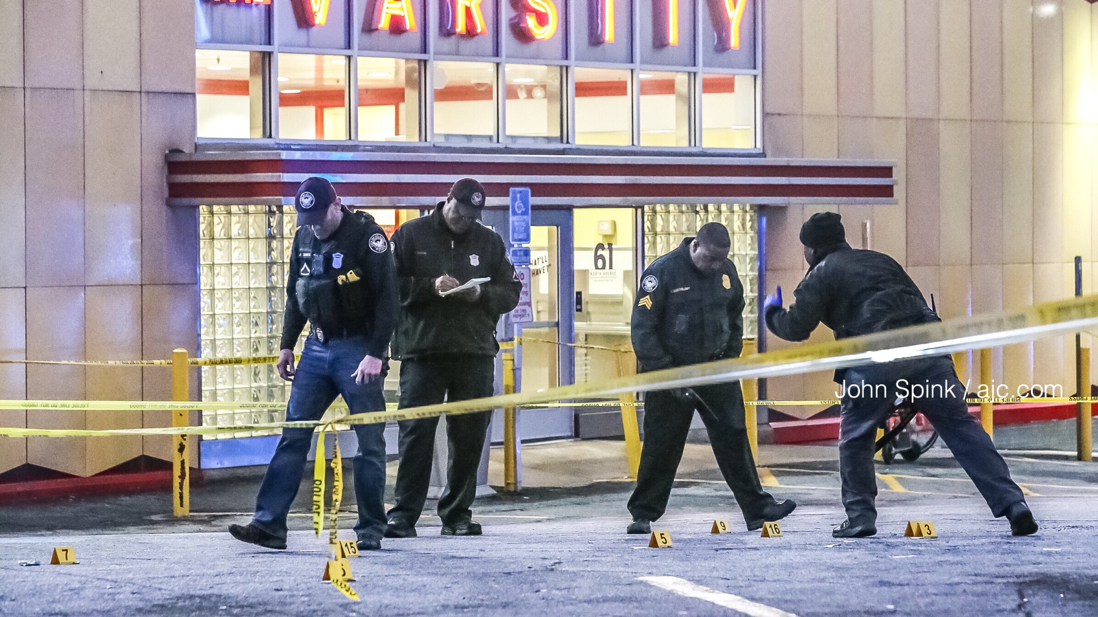 Atlanta police officers collect evidence after a man was shot in the parking lot of the Varsity early Tuesday morning.