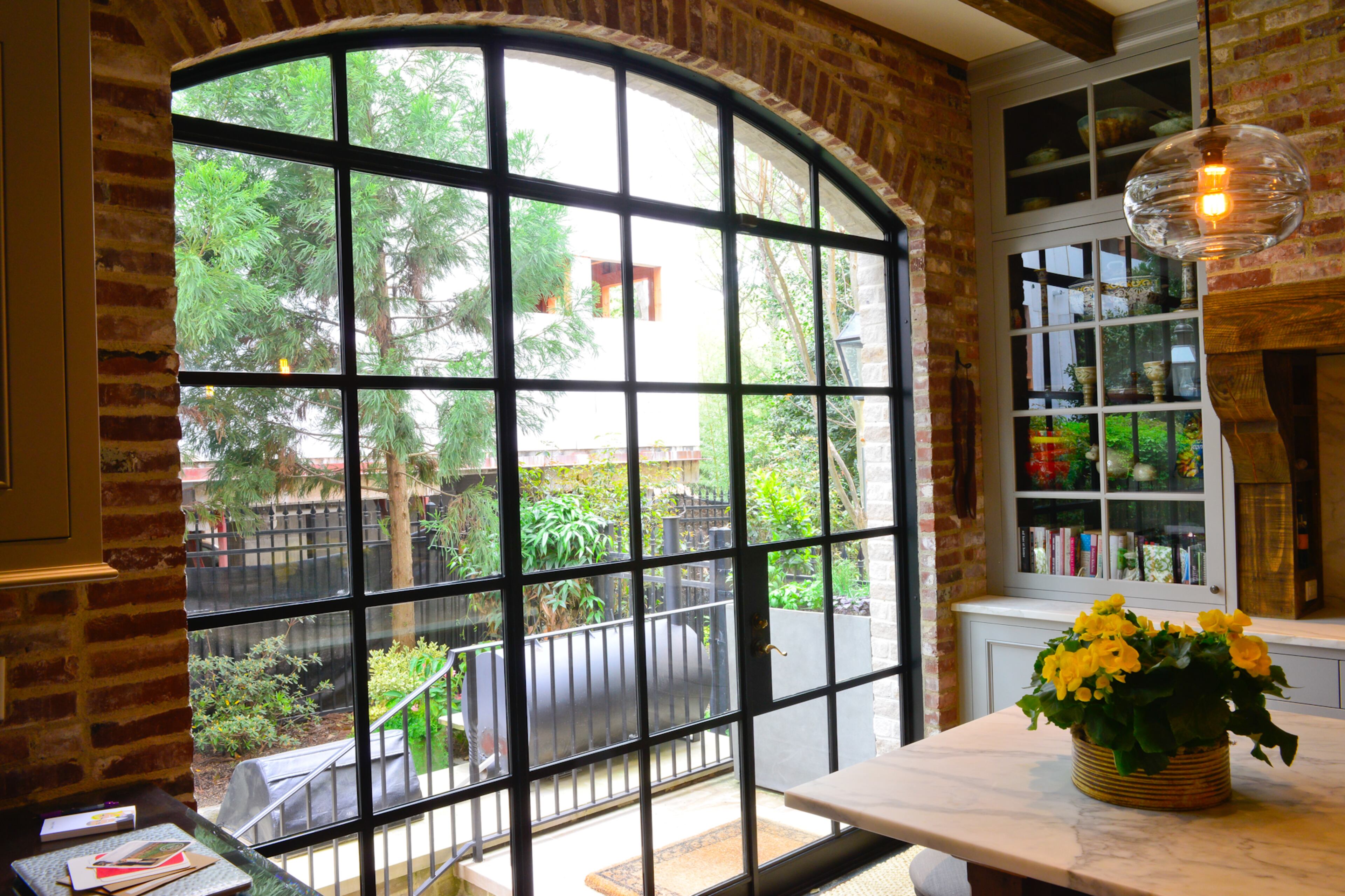 Leading to the patio, there's a centerpiece window and door of rod iron and glass by Lipko Iron Work, based in Canton. The homeowners extended the kitchen but still retained space to entertain and barbecue outside, working with Viridis Garden Design.