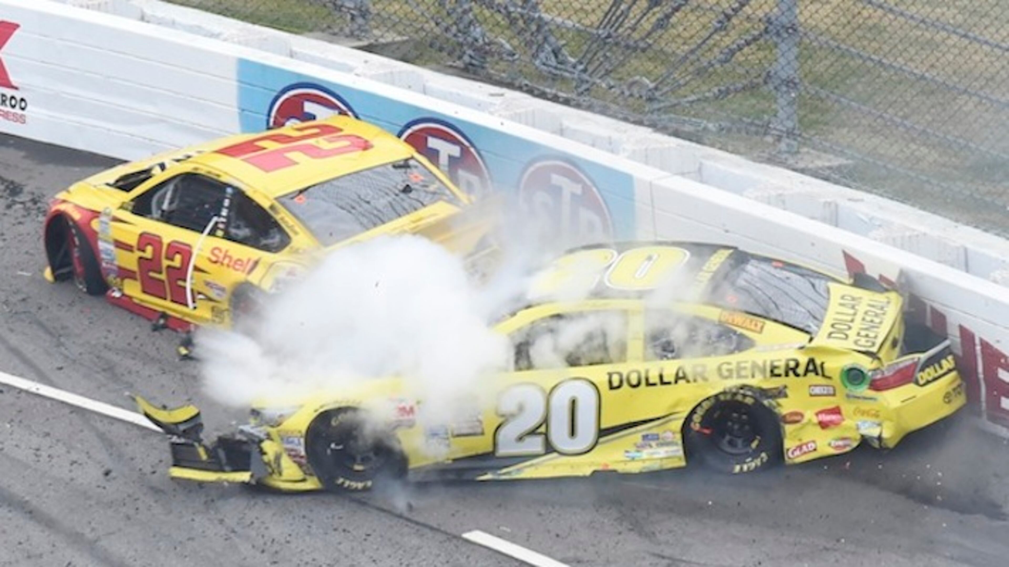 Joey Logano (22) and Matt Kenseth (20) tangle in tun one during the Sprint Cup auto race at the Martinsville Speedway in Martinsville, Va., Sunday, Nov. 1, 2015. (AP Photo/Don Petersen)