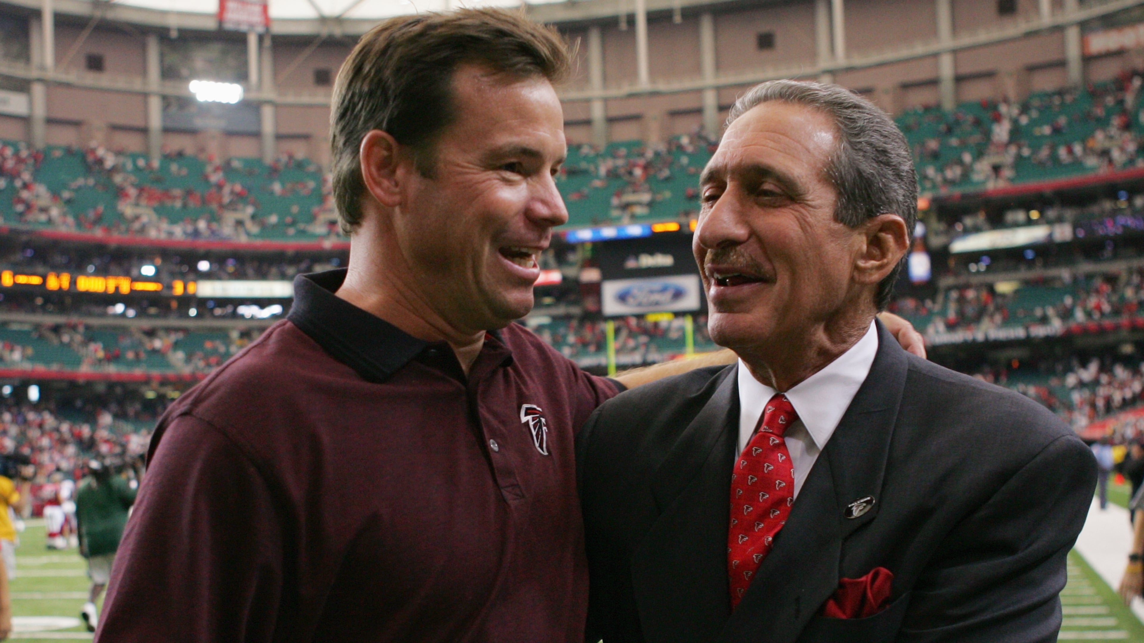Former Falcons head Coach Jim Mora celebrates with team owner Arthur Blank after a game against the Cardinals at the Georgia Dome on September 26, 2004 in Atlanta. The Falcons defeated the Cardinals 6-3.