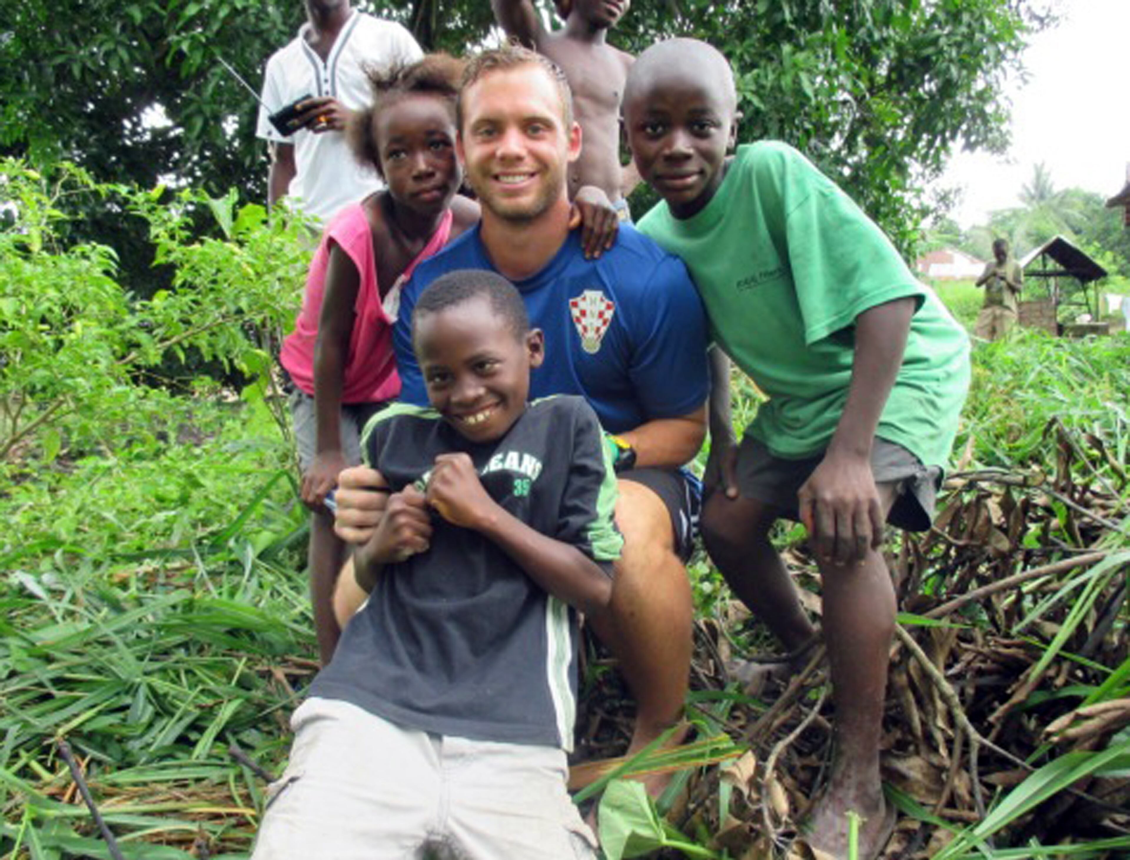 In this photo provided by Dawson Jope, center, Dawson poses with the daughter of his host family, Nancy Bartholomew, left, and her cousins Andala, right, and Solomon, front, in Bo, Sierra Leone. The 25-year-old from Carmichael, Calif., is one of hundreds of Peace Corps volunteer being evacuated from three West African nations affected by the worst recorded Ebola outbreak in history. (AP Photo/Courtesy Dawson Jope)
