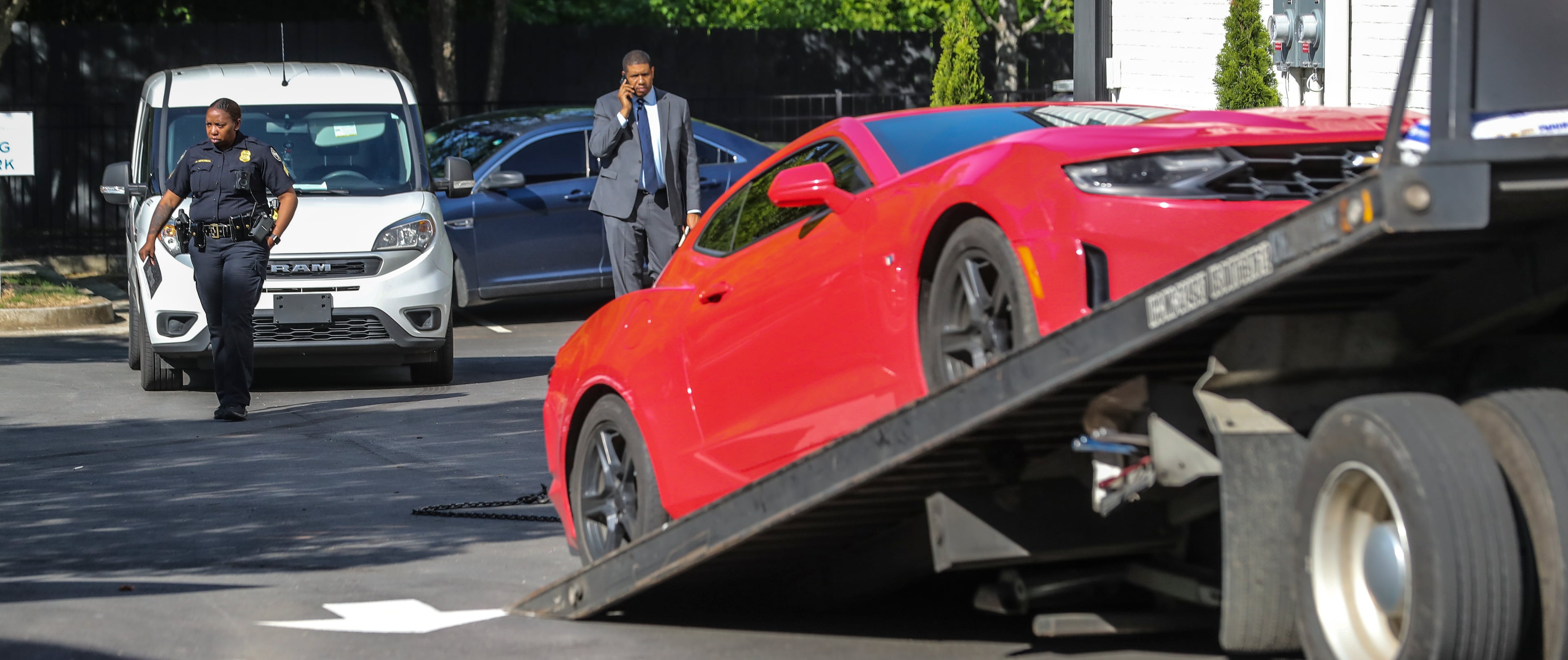 A white work van and a red Chevrolet Camaro were towed from the scene of a fatal shooting at One Riverside West located at 2030 Main Street in northwest Atlanta.