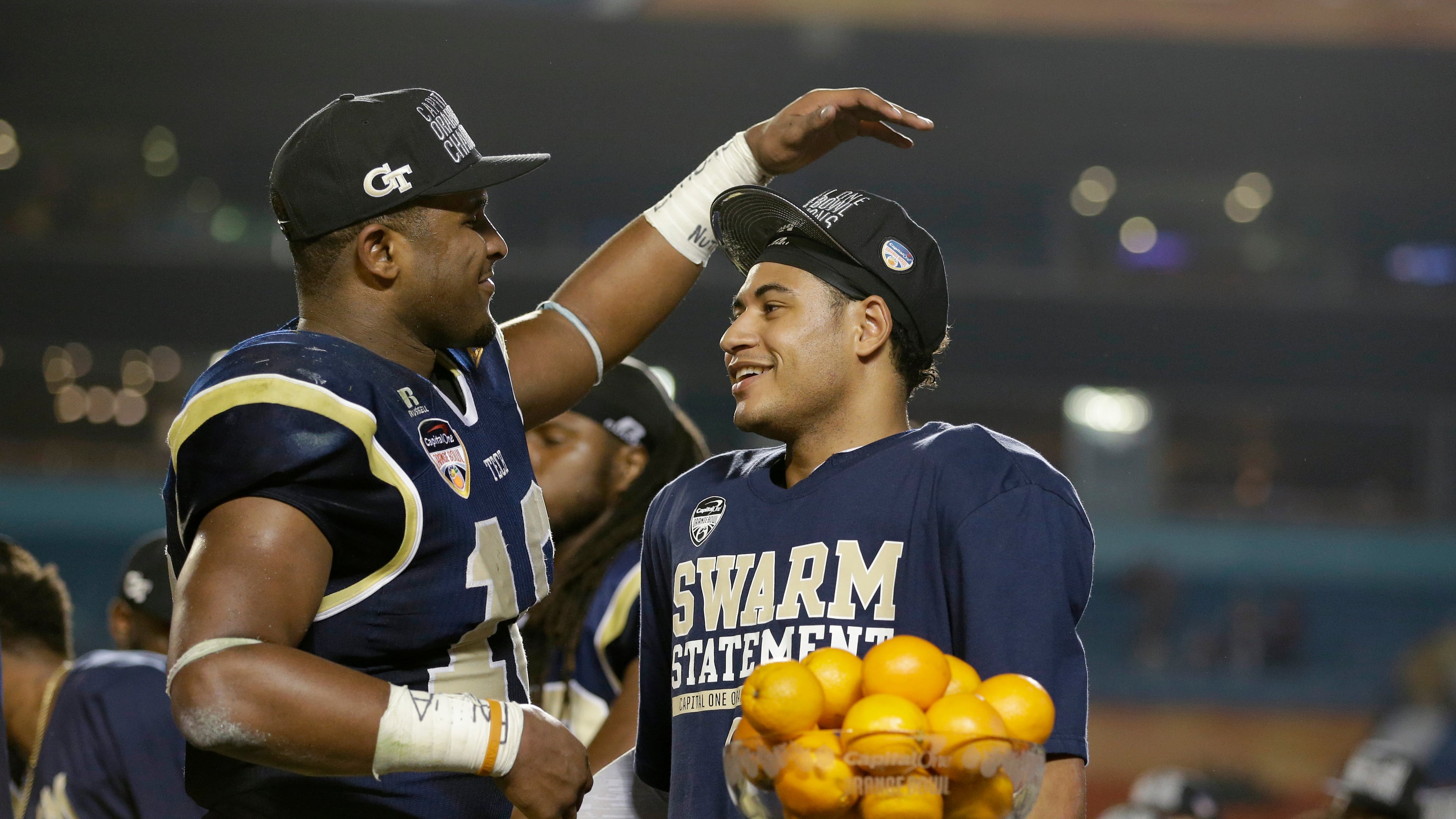 Georgia Tech quarterback Justin Thomas, right, is congratulated by running back Synjyn Days after Thomas was presented with the MVP trophy after Georgia Tech defeated Mississippi State 49-34 in the Orange Bowl NCAA college football game, Wednesday, Dec. 31, 2014, in Miami Gardens, Fla. (AP Photo/Wilfredo Lee)