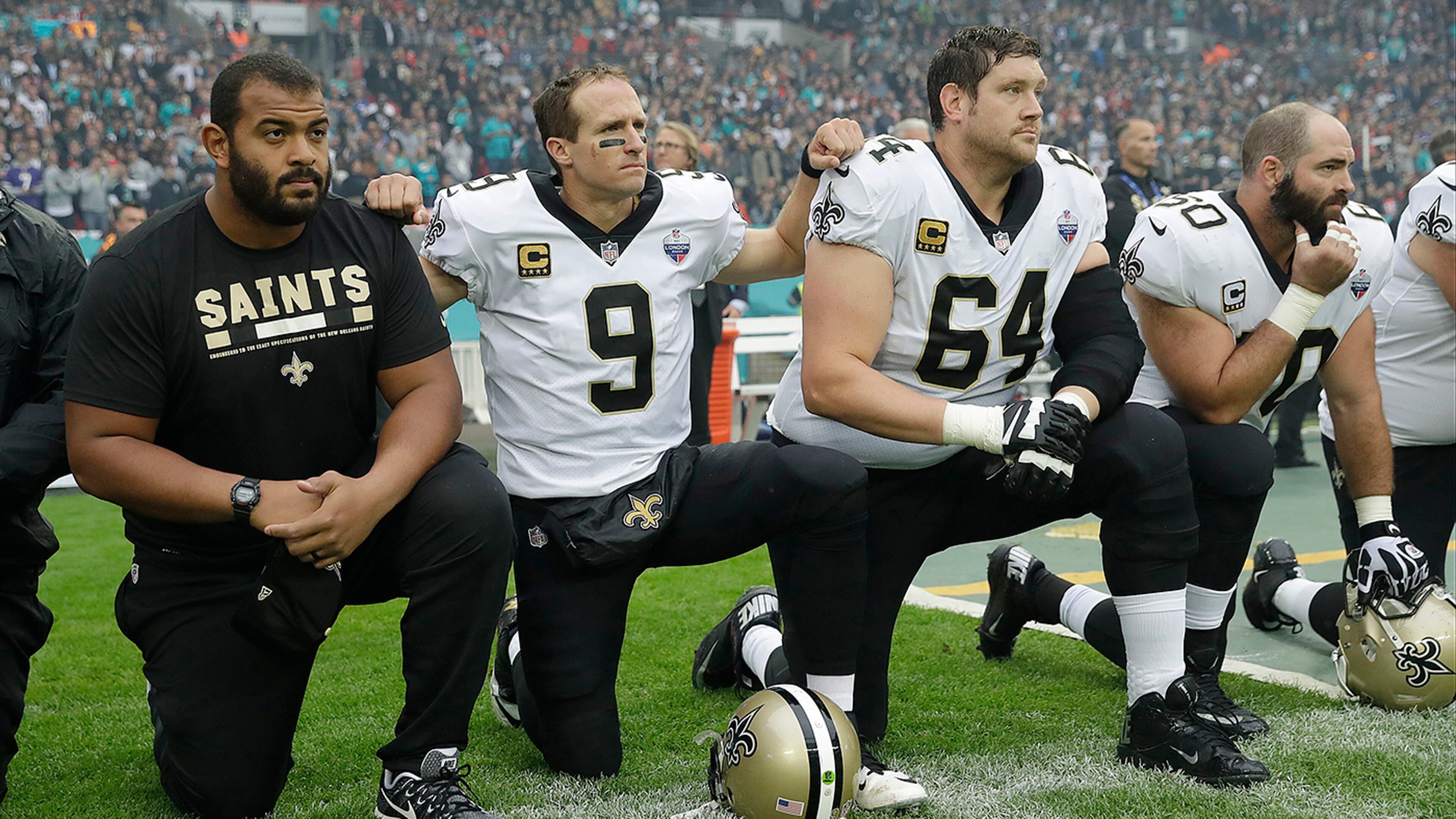New Orleans Saints quarterback Drew Brees (9) kneels down with teammates before the U.S. national anthem was played ahead of an NFL football game against Miami Dolphins at Wembley Stadium in London, Sunday Oct. 1, 2017. Saints players then stood when the anthem was played. (AP Photo/Tim Ireland)
