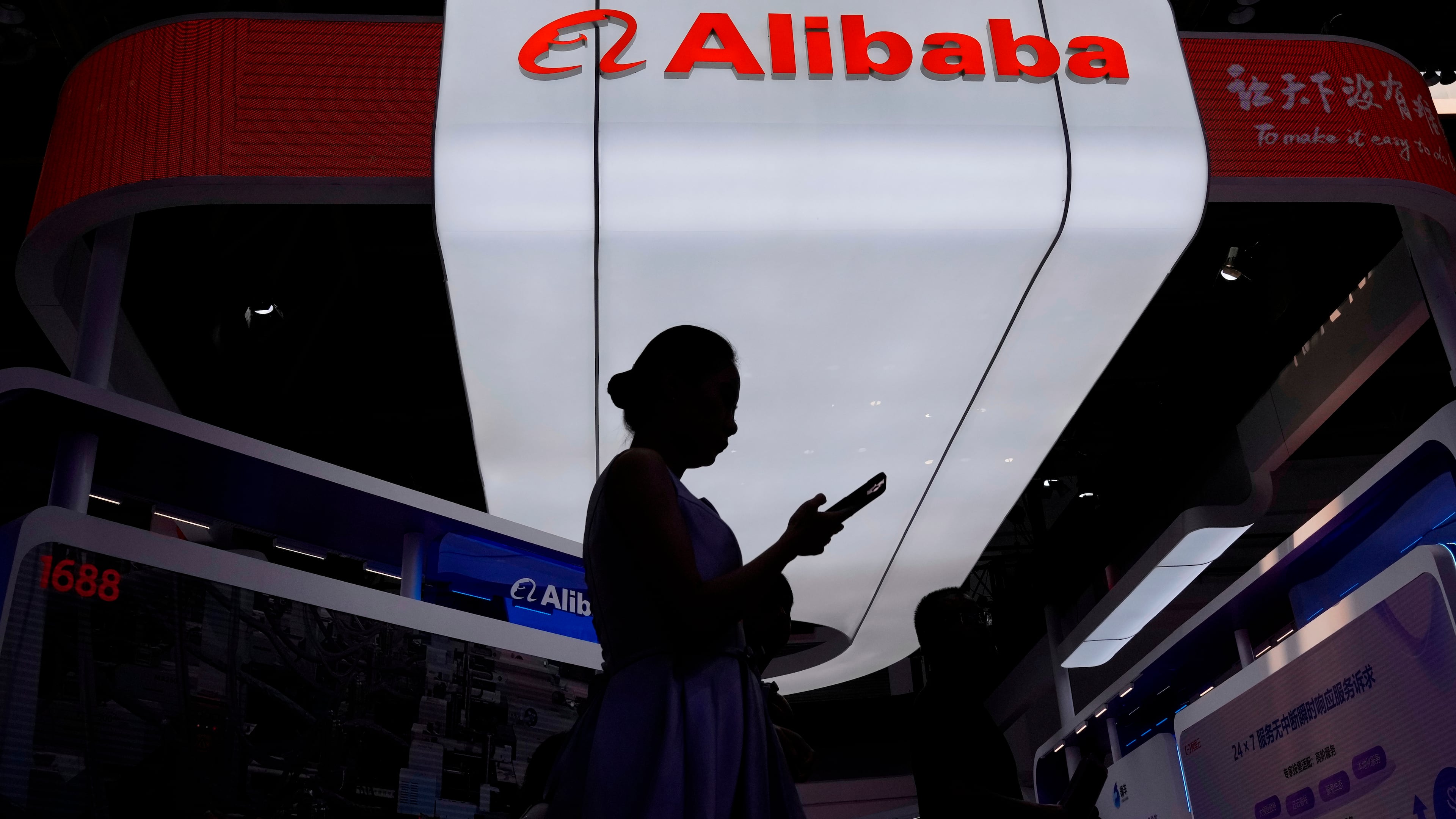 FILE - A visitor walks in front of Alibaba booth during the 3rd China International Supply Chain Expo at the China International Exhibition Center, in Beijing, China, Friday, July 18, 2025. (AP Photo/Mahesh Kumar A., file)