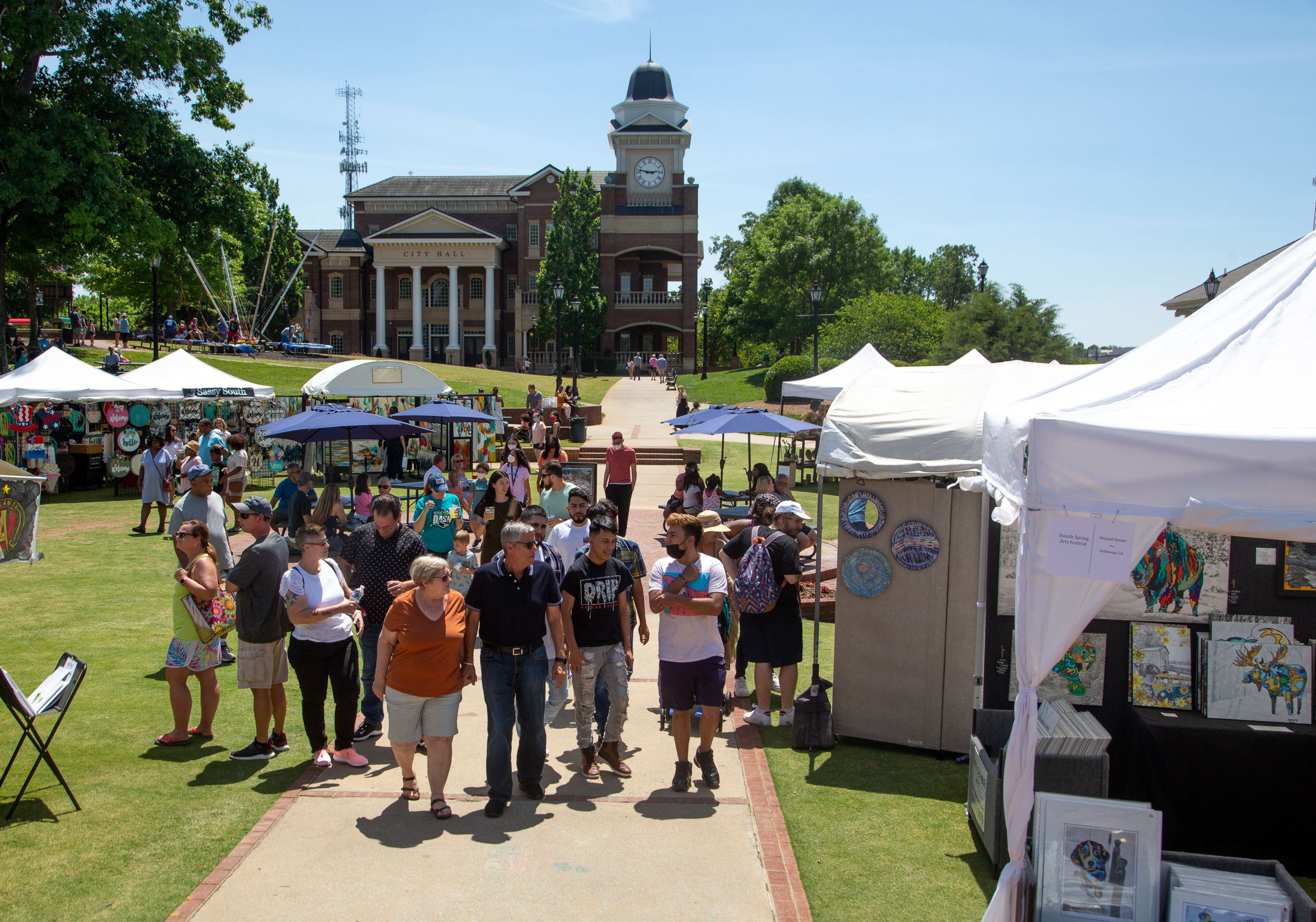 People walk past the artists' tents at the Duluth Arts Festival on Saturday, May 22, 2021. More than 80 painters, photographers, sculptors and glass artists are featured at the event that continues Sunday. (Photo: Steve Schaefer for The Atlanta Journal-Constitution)