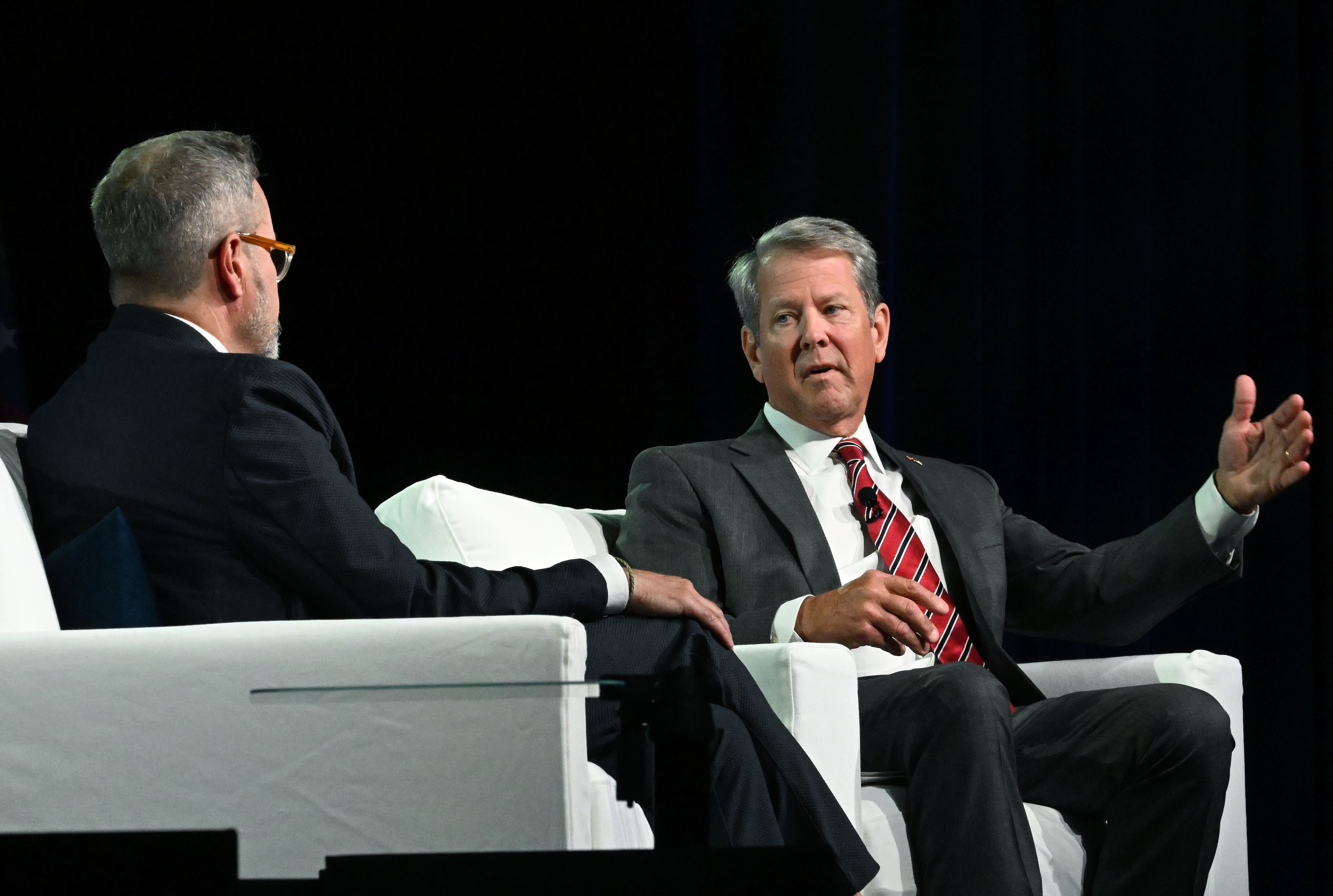 Gov. Brian Kemp (right) speaks as moderator Chris Clark, president and CEO of the Georgia Chamber, listens during the Georgia Chamber Congressional Luncheon on Wednesday in Athens. (Hyosub Shin/AJC)