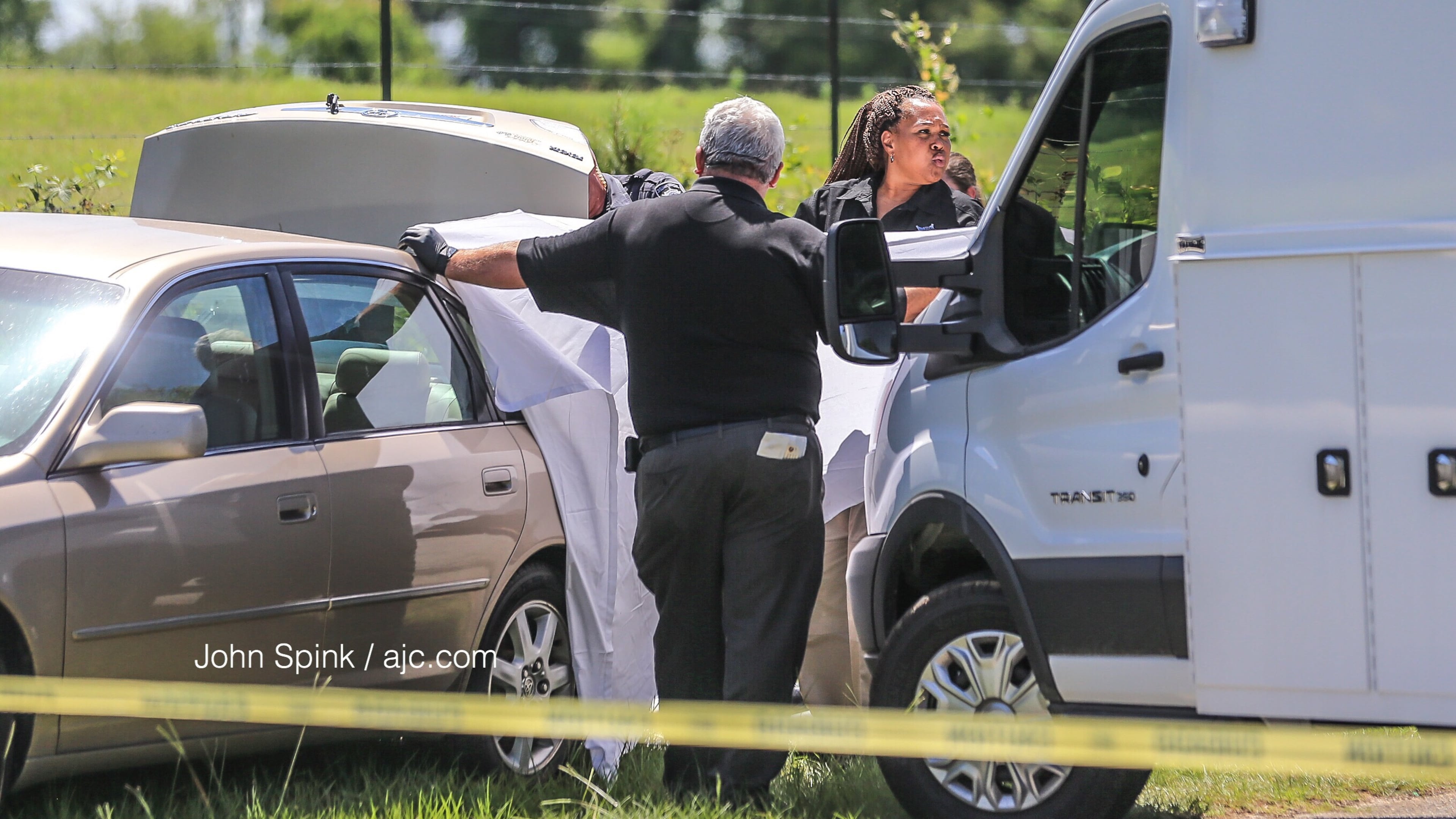 Barrow County Sheriff investigators at Whitley Road and Kilcrease Drive examine a car where a body was found in the trunk.