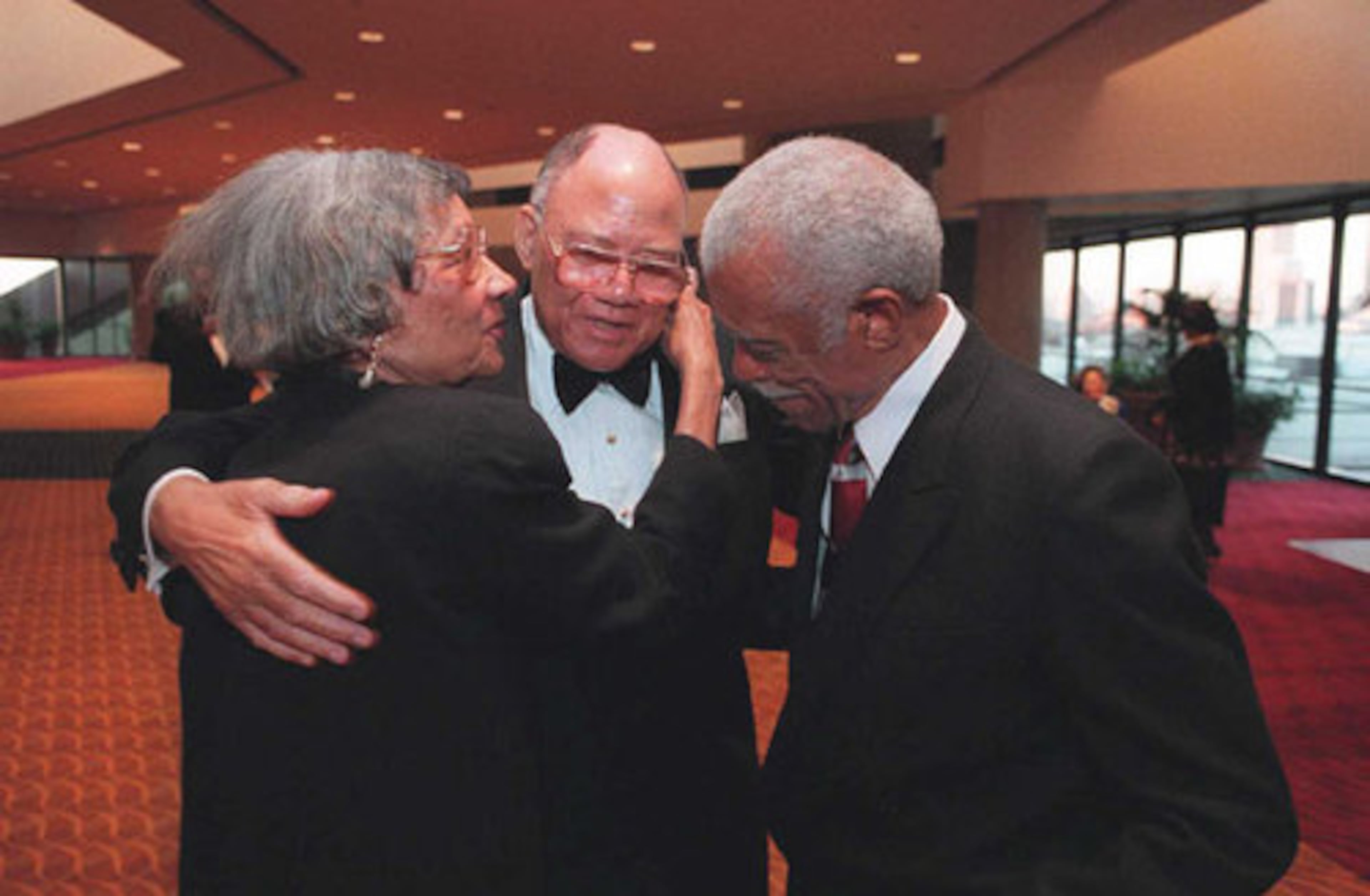 James Paschal (center) receives congratulations and condolensces from Louise and Donald Hollowell at a service honoring Robert Paschal, who died in 1997.
