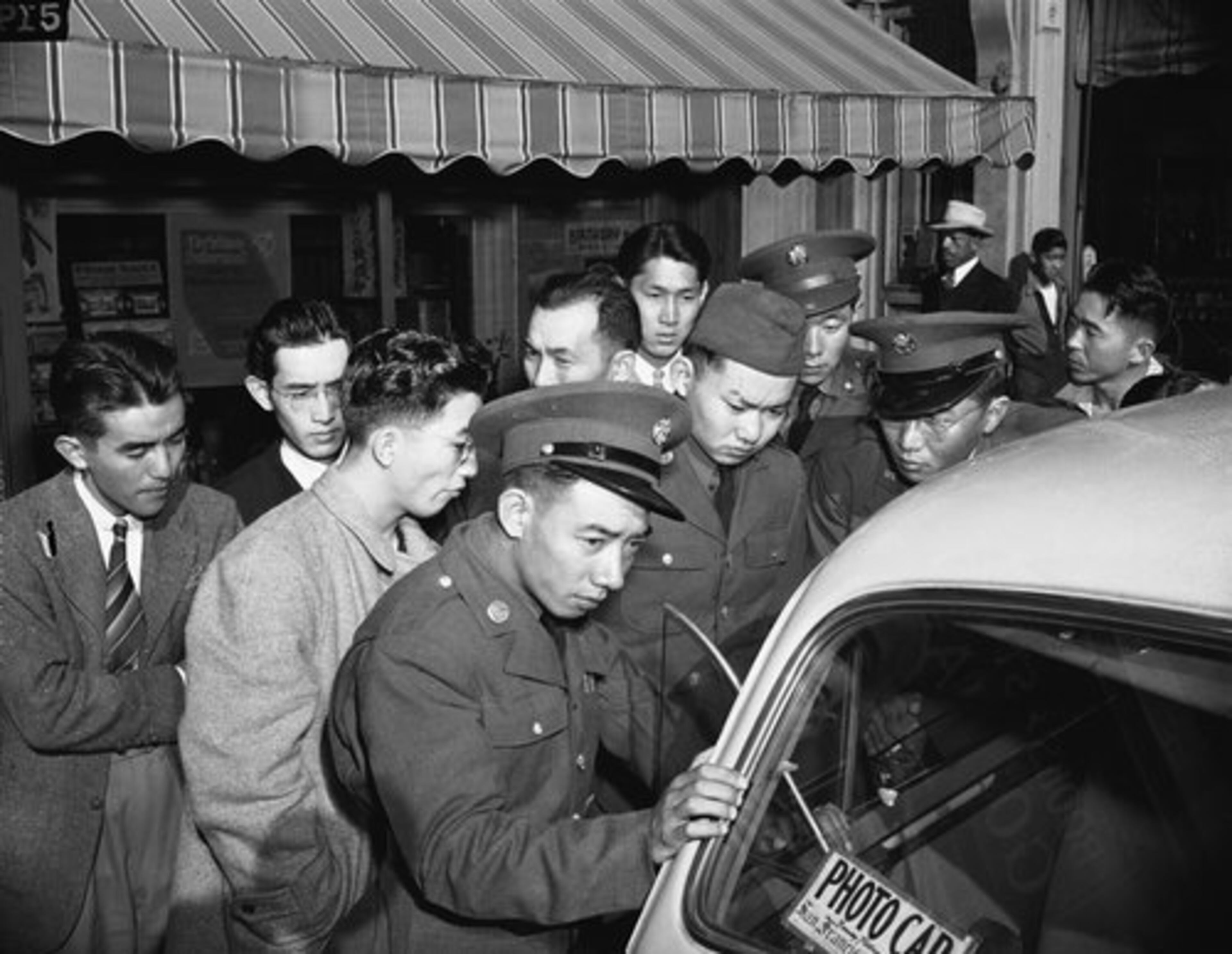 Young Japanese Americans, including several Army selectees, gather around a reporter's car in the Japanese section of San Francisco, Dec. 8, 1941.