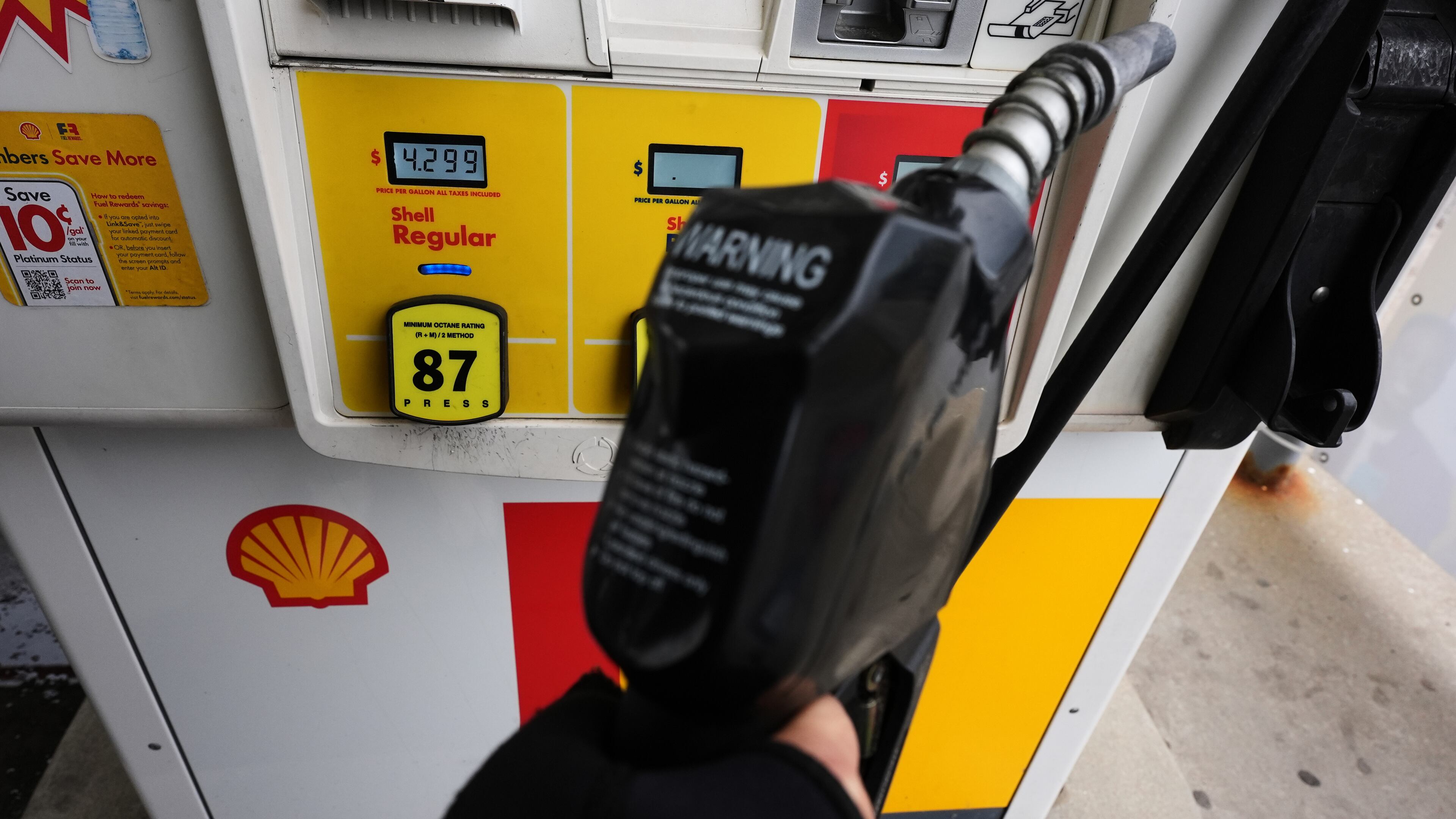 FILE - A gas price is displayed as a customer holds a fuel pump nozzle before filling up her vehicle's gas tank at a gas station, in Lincolnshire, Ill., Wednesday, April 15, 2026. (AP Photo/Nam Y. Huh, file)