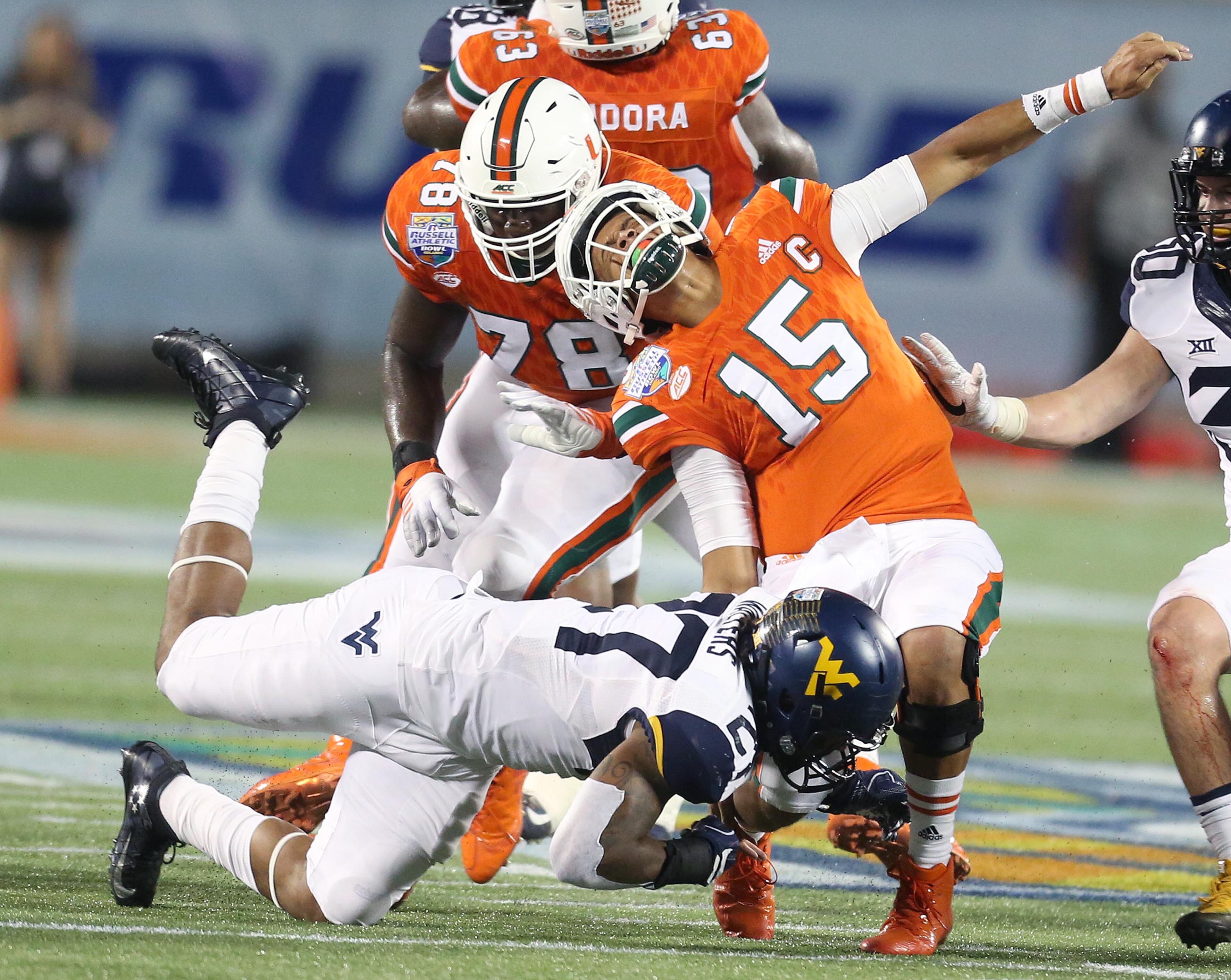 Miami quarterback Brad Kaaya (15) is pulled down by West Virginia linebacker Sean Walters (27) during the Russell Athletic Bowl at Camping World Stadium in Orlando, Fla., on Wednesday, Dec. 28, 2016. (Stephen M. Dowell/Orlando Sentinel/TNS)