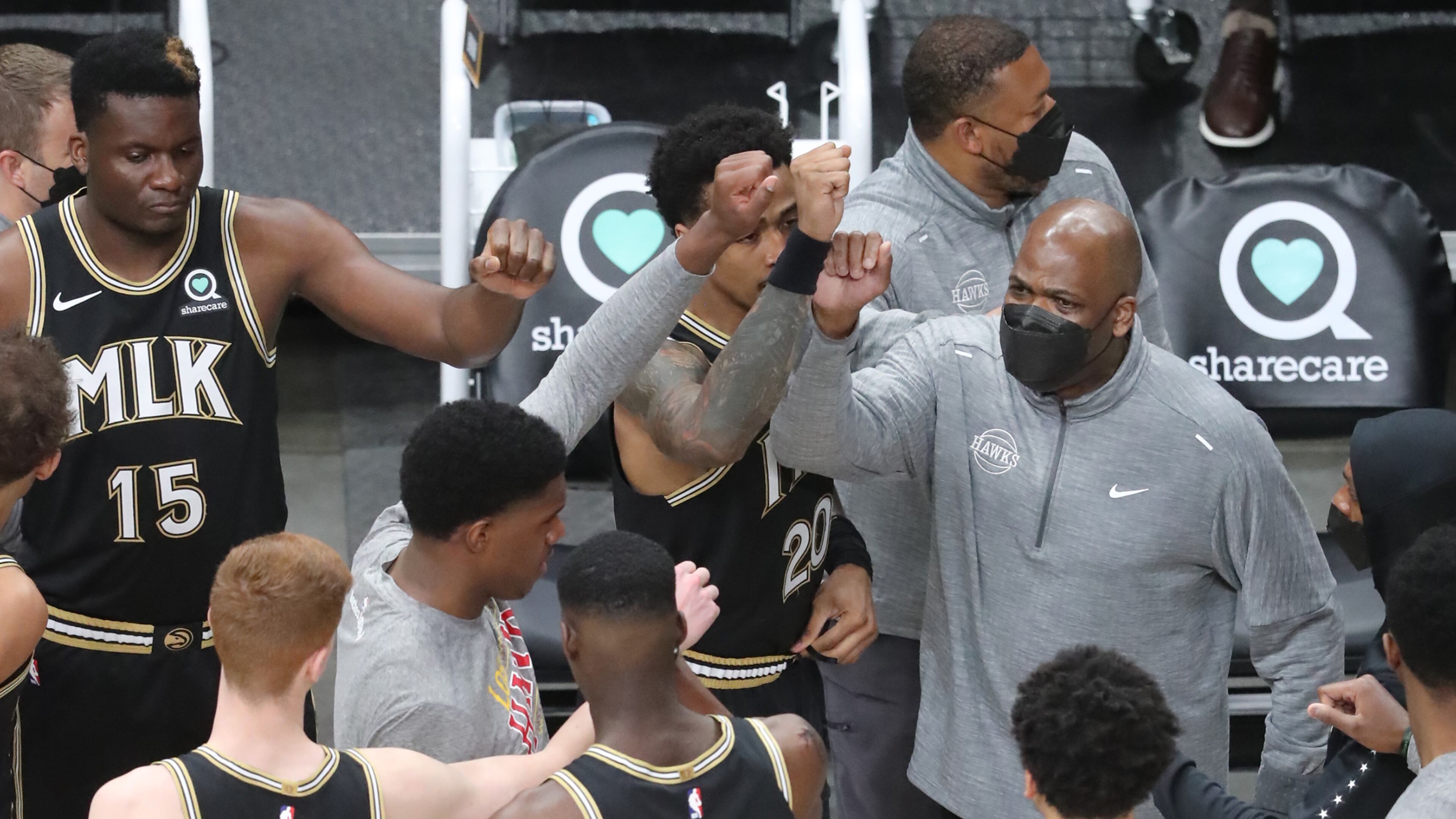 Hawks head coach Nate McMillan gives his players a fist bump as they take the court in March. “Curtis Compton / Curtis.Compton@ajc.com”