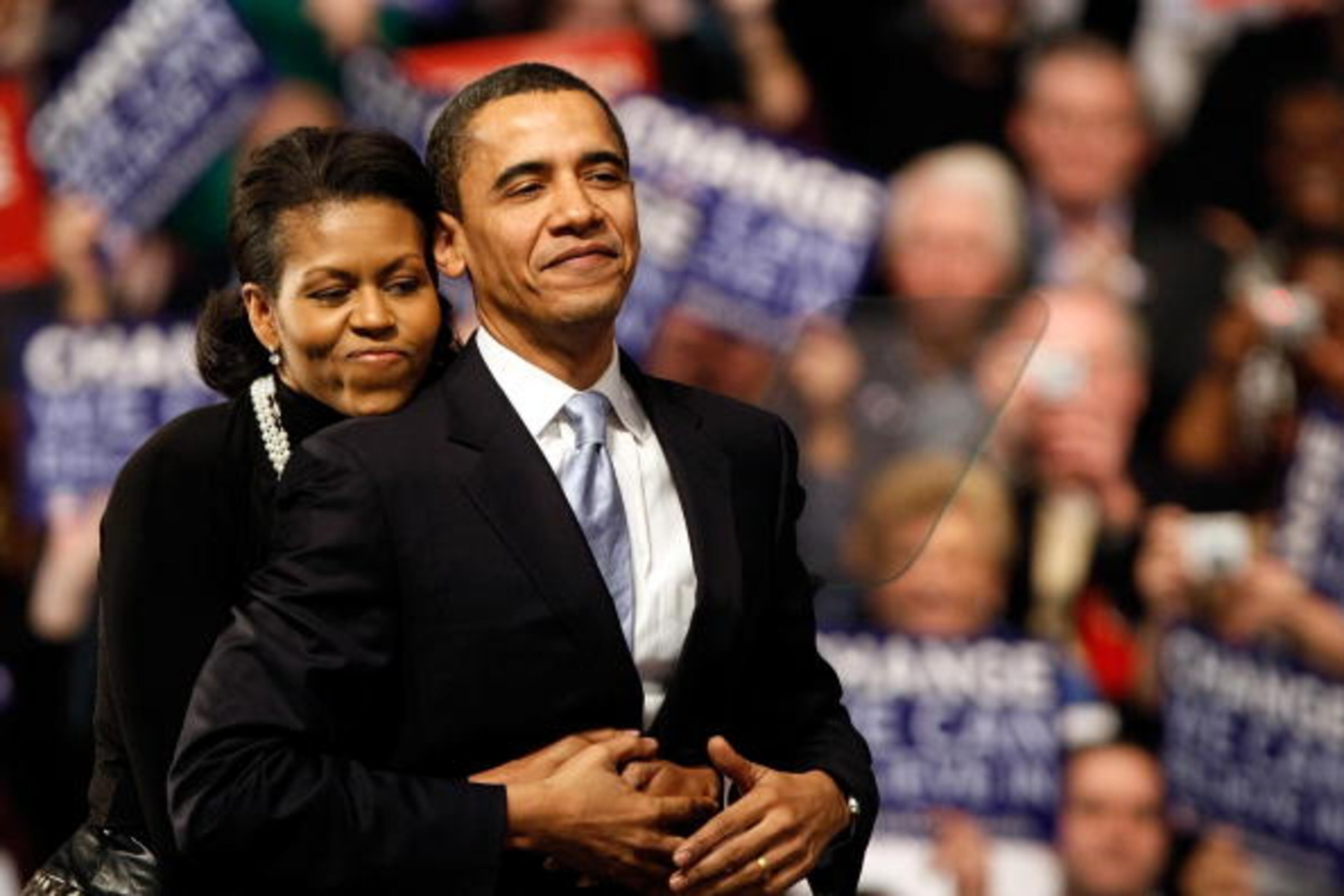 NASHUA, NH - JANUARY 08: Democratic presidential hopeful Sen. Barack Obama (D-IL) is hugged by his wife Michelle Obama before his speech at a primary night rally in the gymnasium at the Nashua South High School on January 8, 2008 in Nashua, New Hampshire. Obama finished a projected 2nd place behind Sen. Hillary Clinton (D-NY) in the nation's first democratic primary (Photo by Win McNamee/Getty Images)
