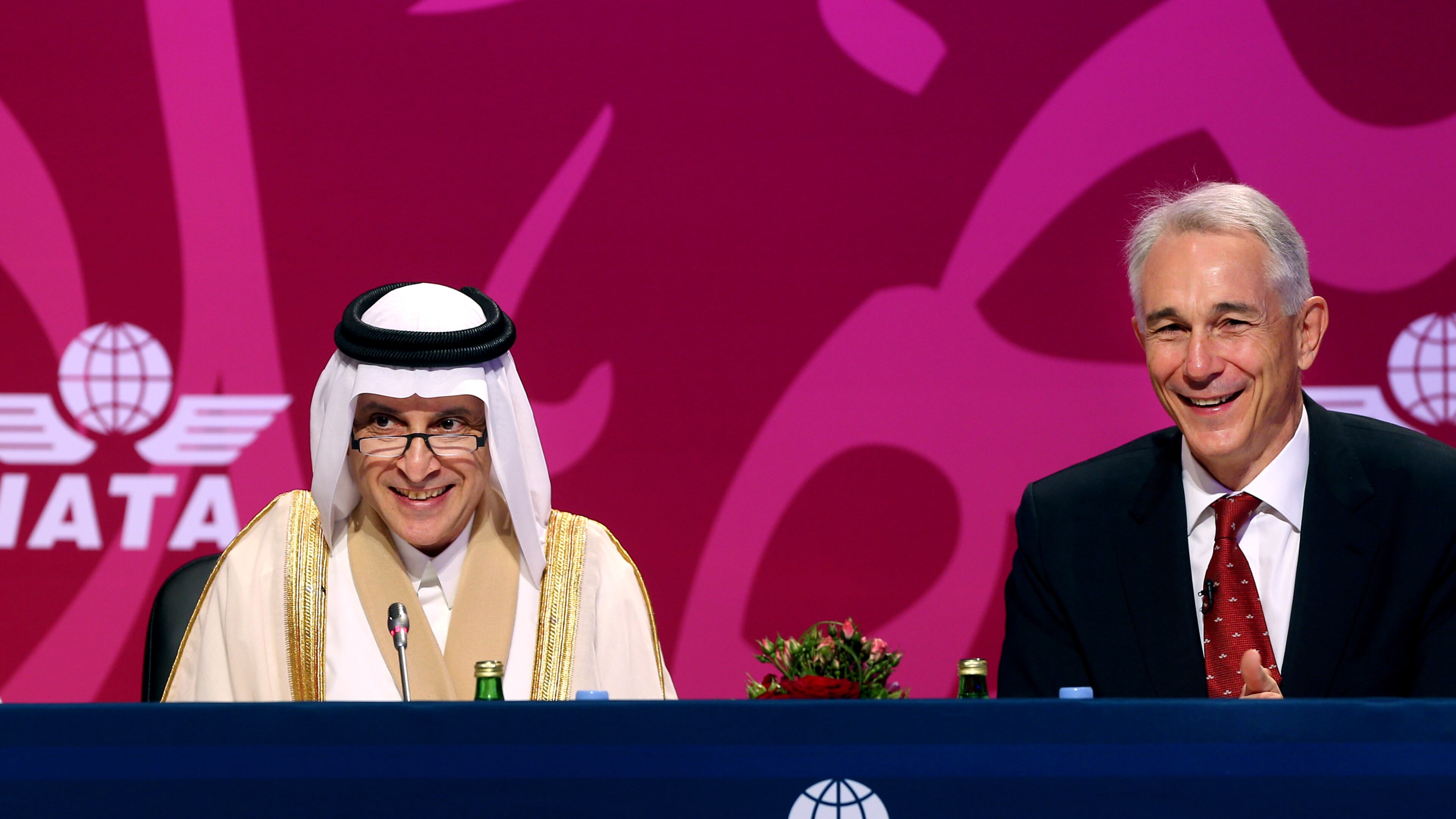Qatar Airways Chief Executive Officer Akbar Al Baker, left, and International Air Transport Association director Tony Tyler laugh during the the IATA's annual meeting held this year in Doha, Qatar, Monday, June 2, 2014. Tyler says the group will prepare a draft of new recommendations in September to improve global tracking capabilities in the aftermath of the disappearance of Malaysia Airlines Flight 370. (AP Photo/Osama Faisal)