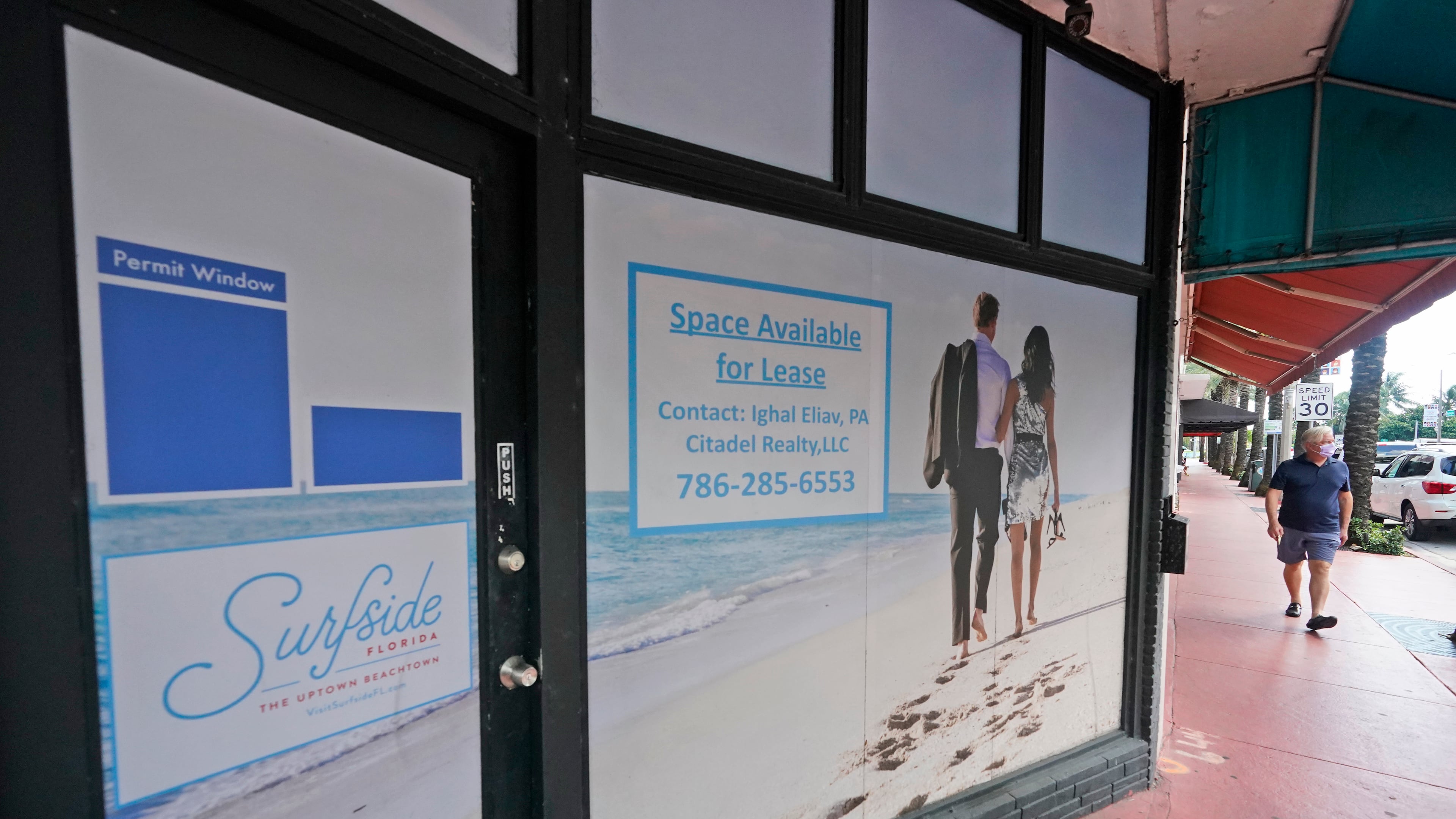 A pedestrian walks past an empty business available for lease, Monday, Oct. 12, 2020, in downtown Surfside, Fla. (AP Photo/Wilfredo Lee)