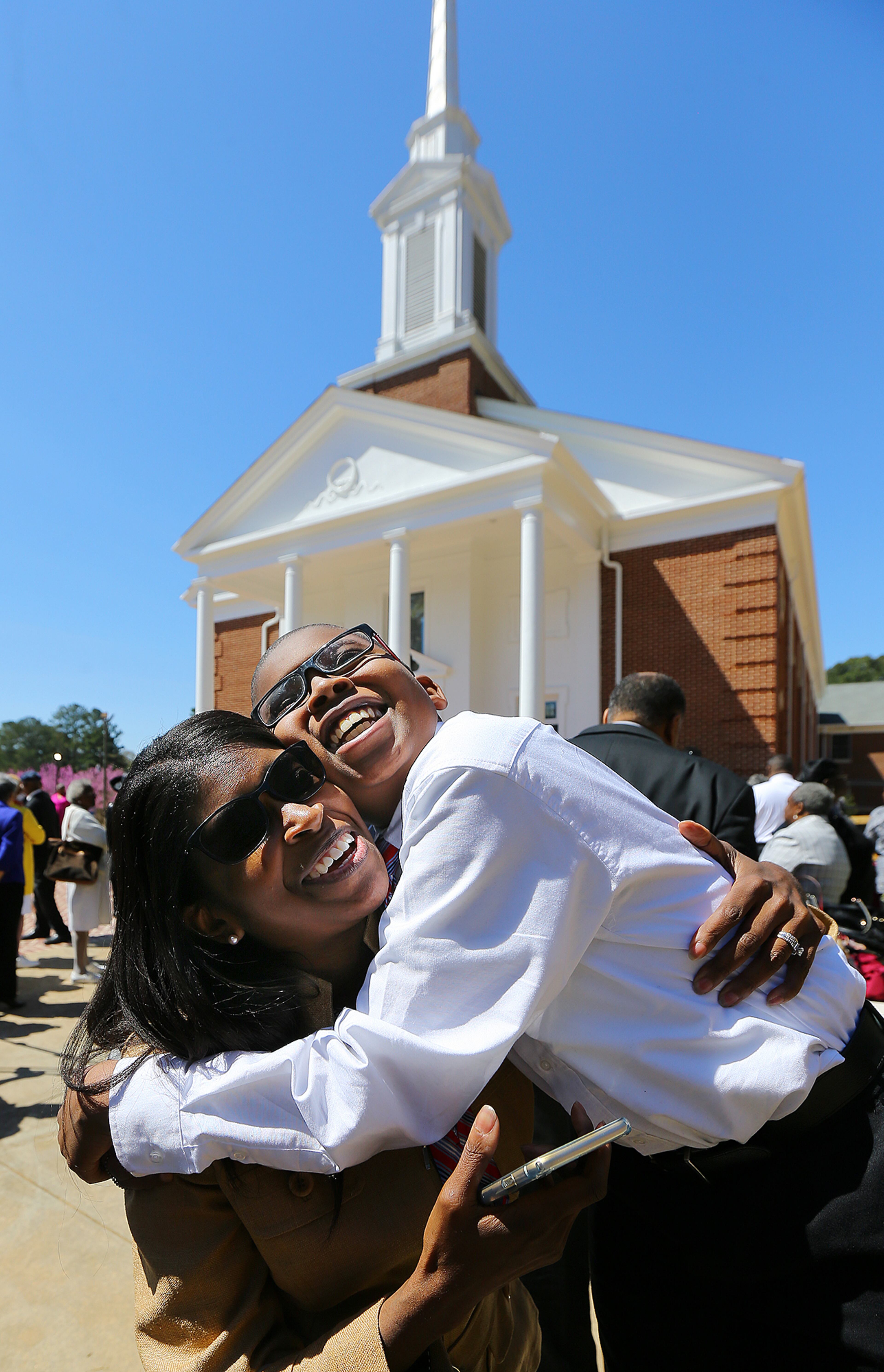 Visitor Melanie Gallo gets a joyous hug from her son Preston Jackson, 11, during the Entrance Service into Mount Vernon Baptist Church on Palm Sunday, March 29, 2015, in Atlanta. The church moved locations to make way for the Falcons new stadium. Curtis Compton / ccompton@ajc.com
