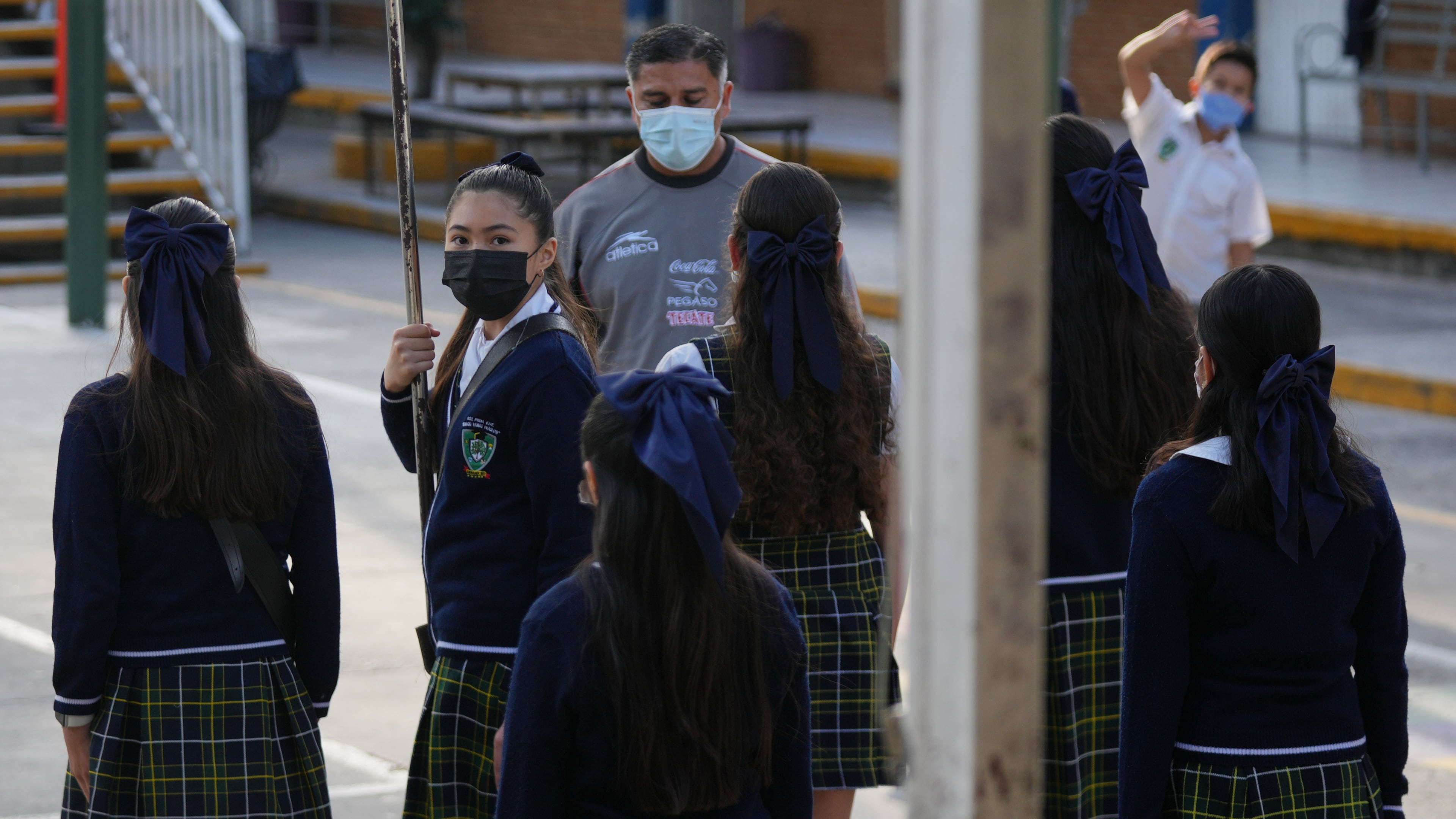 Public school students and teachers wear mandatory face masks amid a measles outbreak, during a ceremony at their school in Guadalajara, Mexico, Thursday, Feb. 5, 2026. (AP Photo/Fernando Llano)