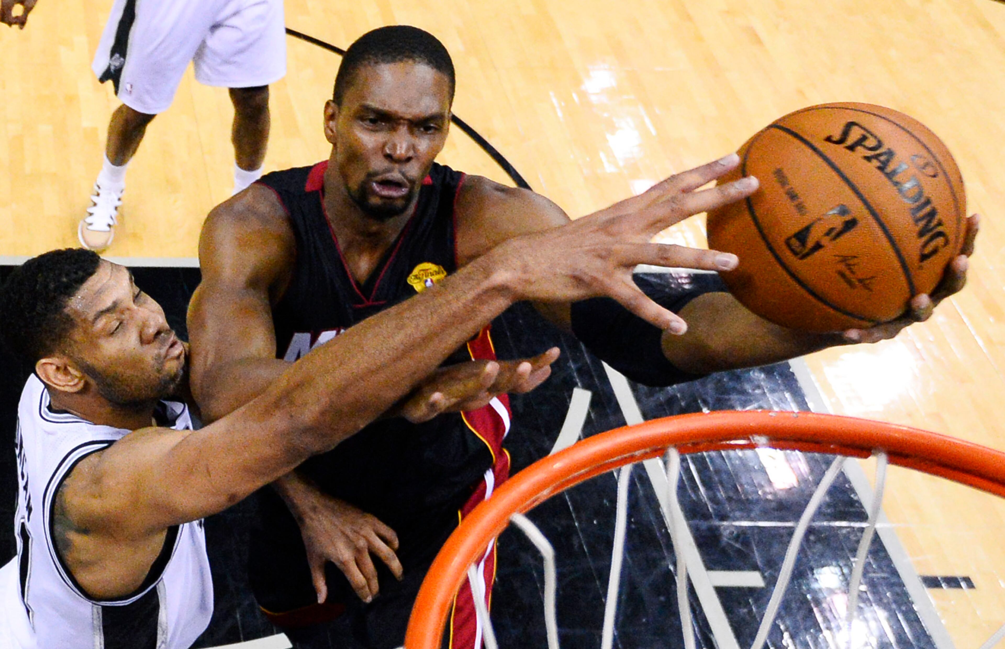 Miami Heat center Chris Bosh shoots as San Antonio Spurs forward Tim Duncan, left, defends during the first half in Game 2 of the NBA basketball finals on Saturday, Nov. 8, 2014, in San Antonio. (AP Photo/Larry W. Smith, pool)