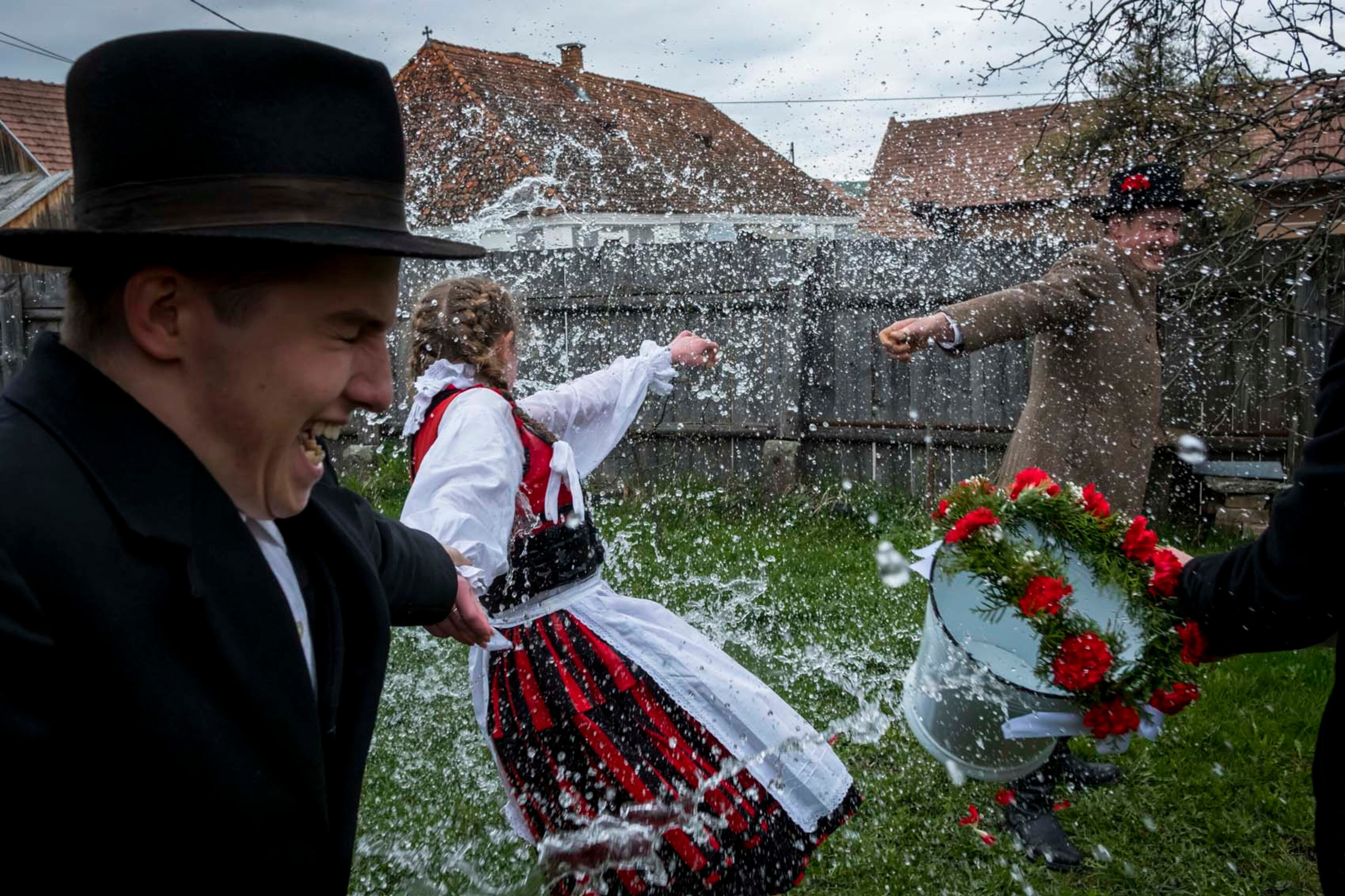 A young woman is held by both arms and doused with water during âSprinkling,â a Transylvanian rite of spring, in Sancraieni, Romania, April 17, 2017. Many here see the rite as a way to keep folk traditions alive, though some women view it as dated and sexist, something to be endured. (Andrei Pungovschi/The New York Times)
