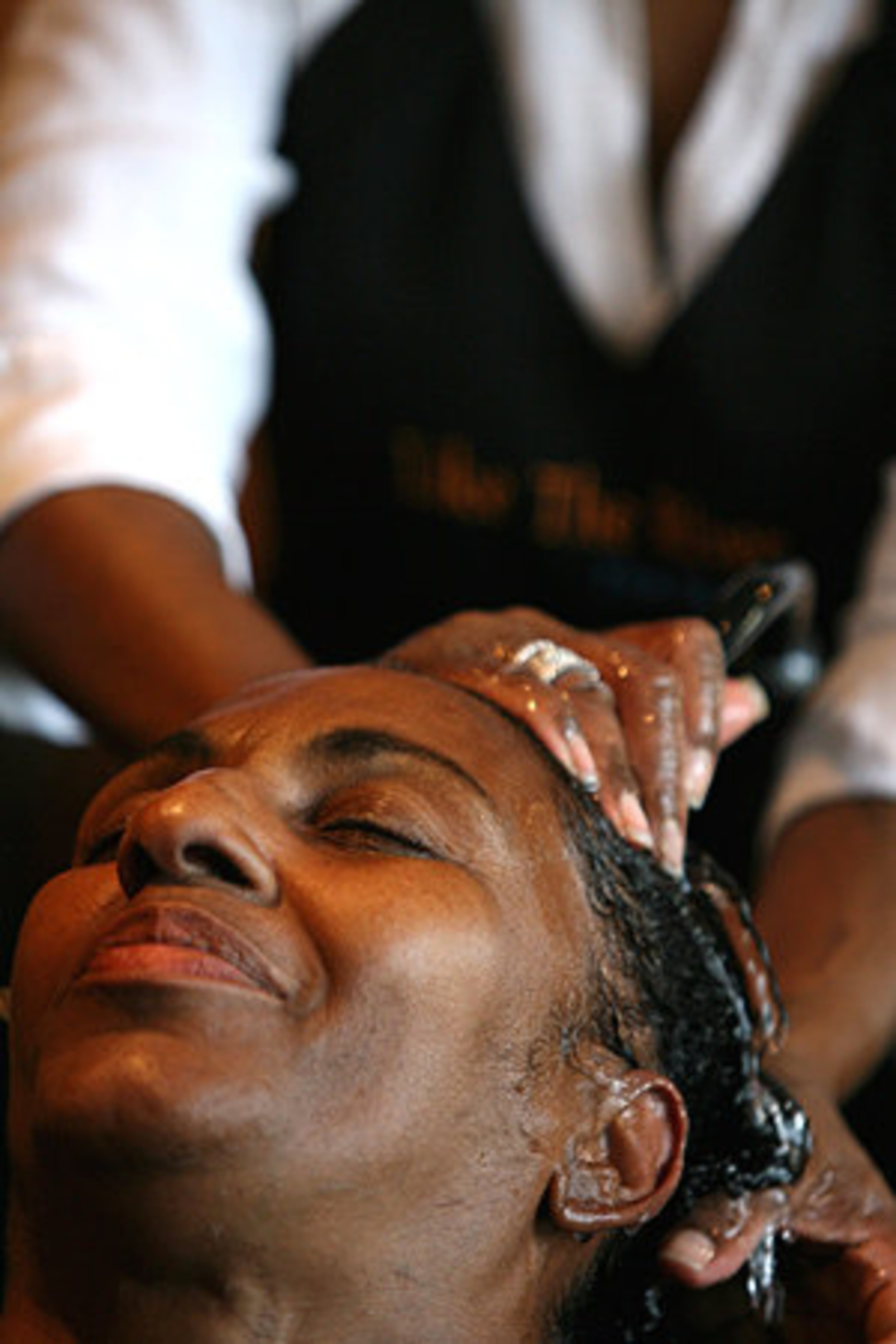 After a ride in a limousine from the women's shelter, Yvonne Henderson relaxes during a shampooing at Like the River.