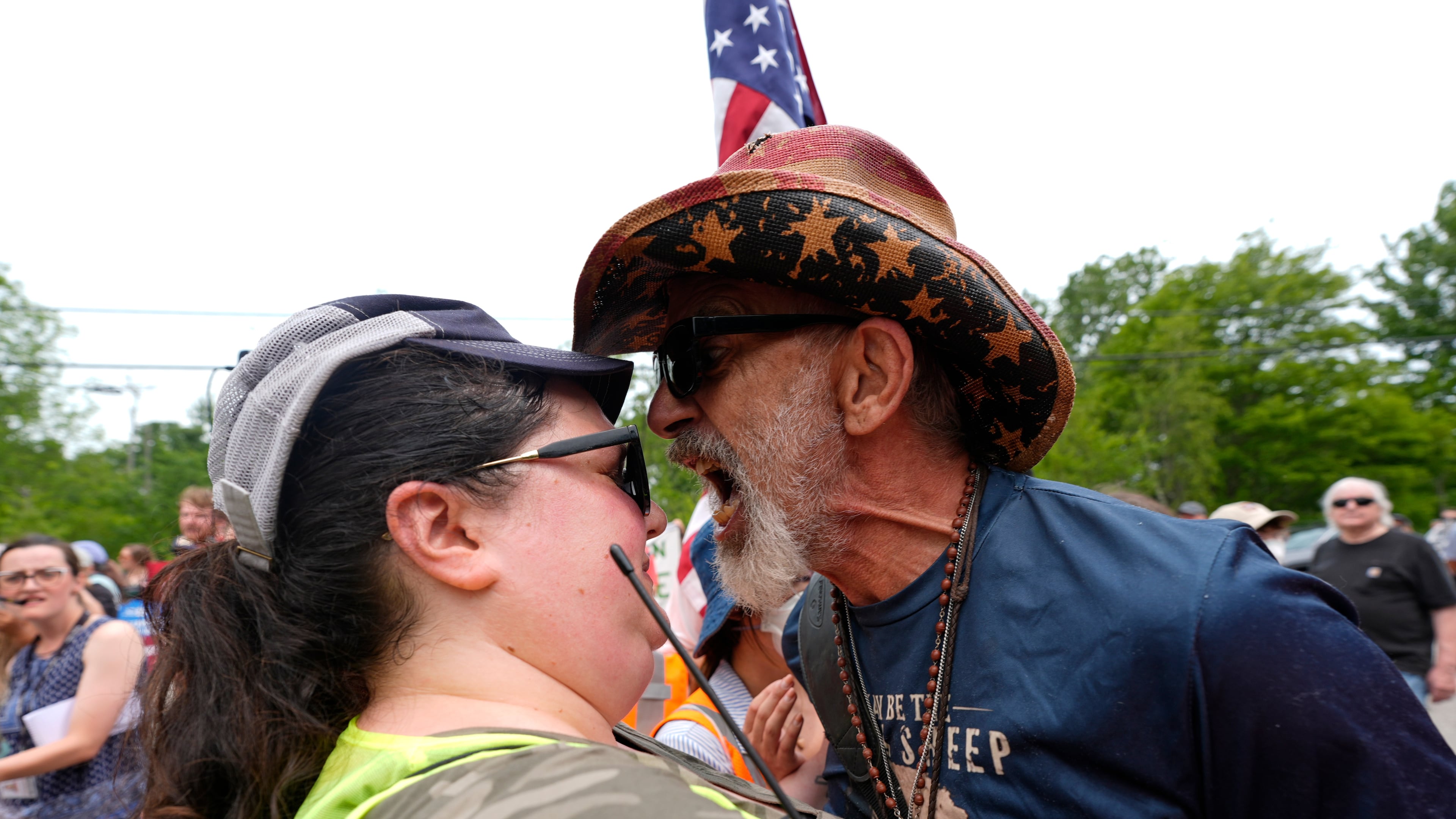 A man yells at a woman working security near a U.S. Immigration and Customs Enforcement facility in Scarborough, Maine, one day after the shooting of Johan Sebastián Durán Guerrero, Tuesday, July 14, 2026. (AP Photo/Robert F. Bukaty)