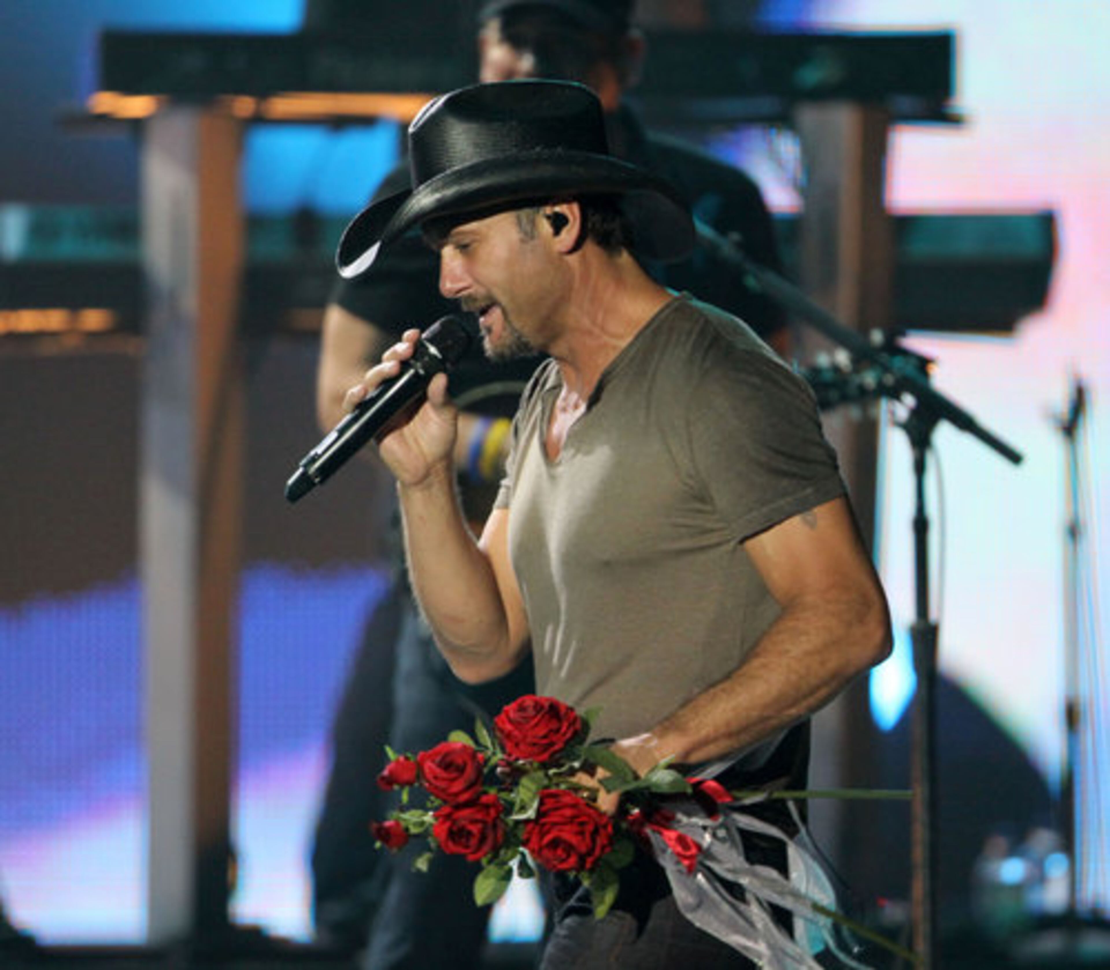 Tim McGraw holds roses from a fan in the front row.