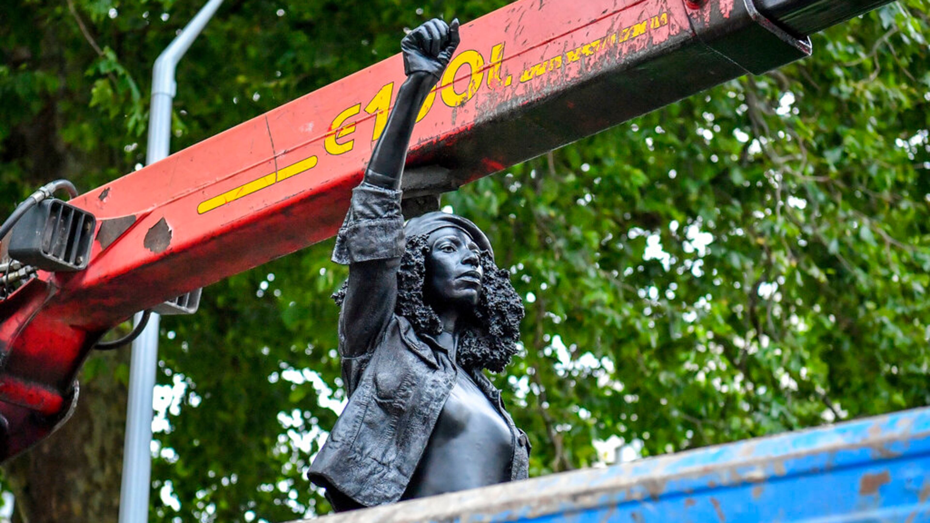Contractors remove the statue "A Surge of Power (Jen Reid) 2020" by artist Marc Quinn, which had been installed on the site of the fallen statue of the slave trader Edward Colston, in Bristol, England, Thursday, July 16, 2020. The sculpture of protester Jen Reid was installed without the knowledge or consent of Bristol City Council and was removed by the council 24 hours later. (Ben Birchall/PA via AP)