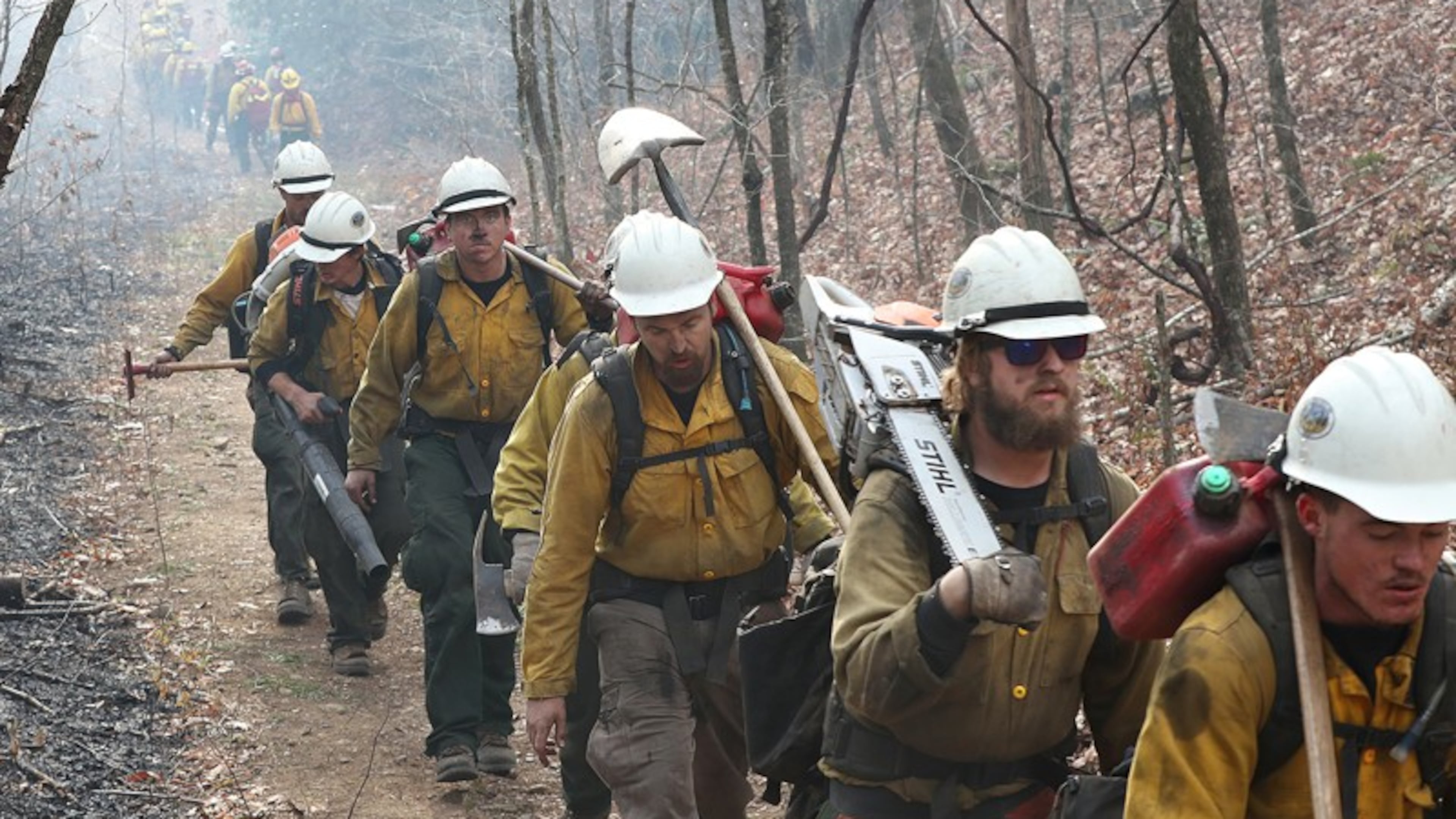 A California fire crew (right) walks toward the Rock Mountain fire last week while an Oregon crew (back) heads out after a long shift. CURTIS COMPTON / CCOMPTON@AJC.COM